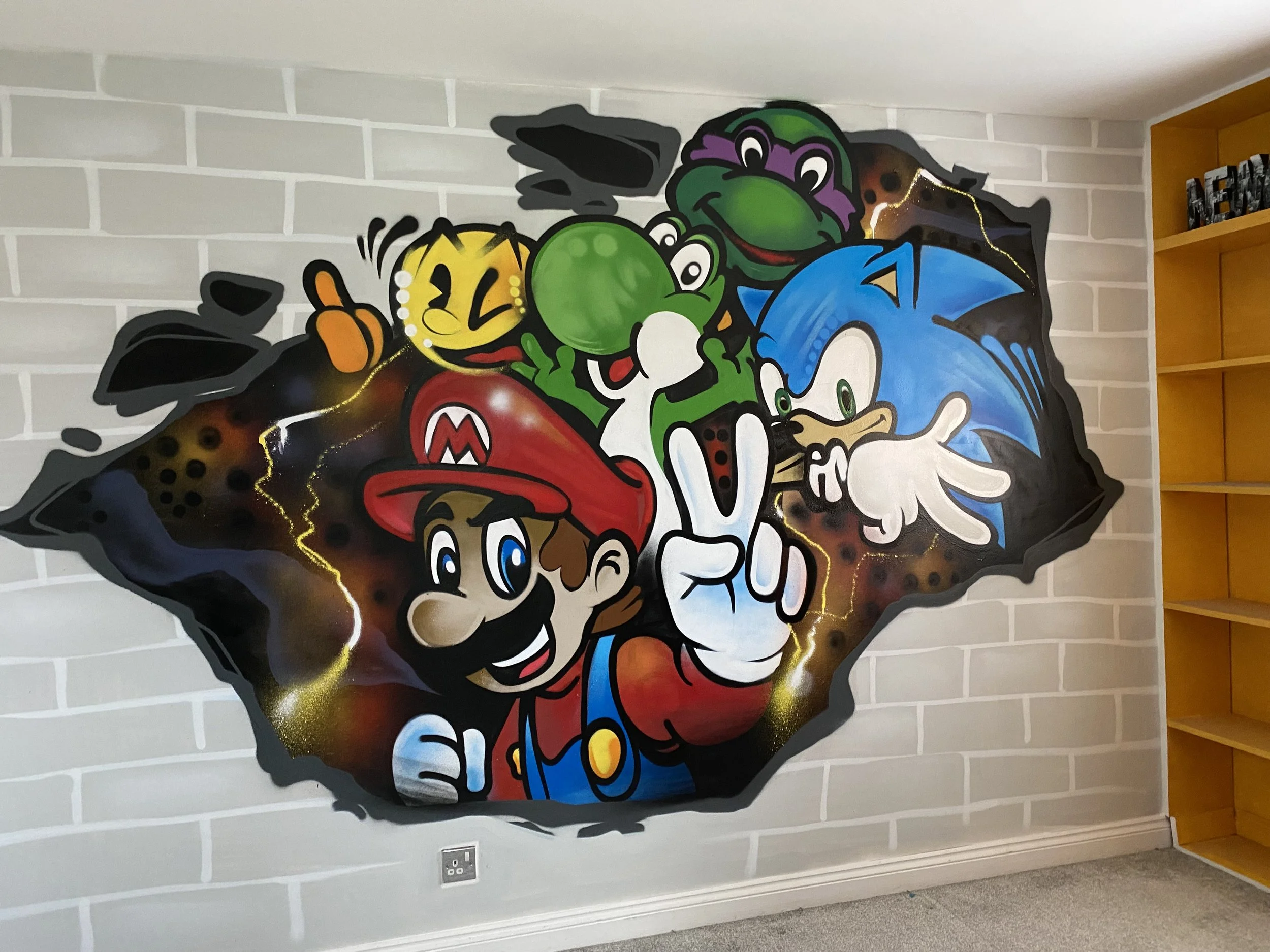 Colorful wall mural featuring Mario, Luigi, Sonic the Hedgehog, Yoshi, and Donkey Kong from popular video games, depicted on a torn paper background with lightning accents.