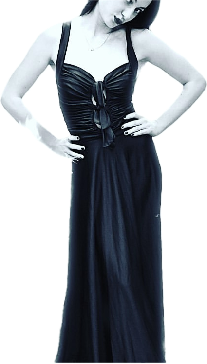 A woman wearing a black sleeveless dress with a tied front bodice, standing with hands on hips against a plain background.