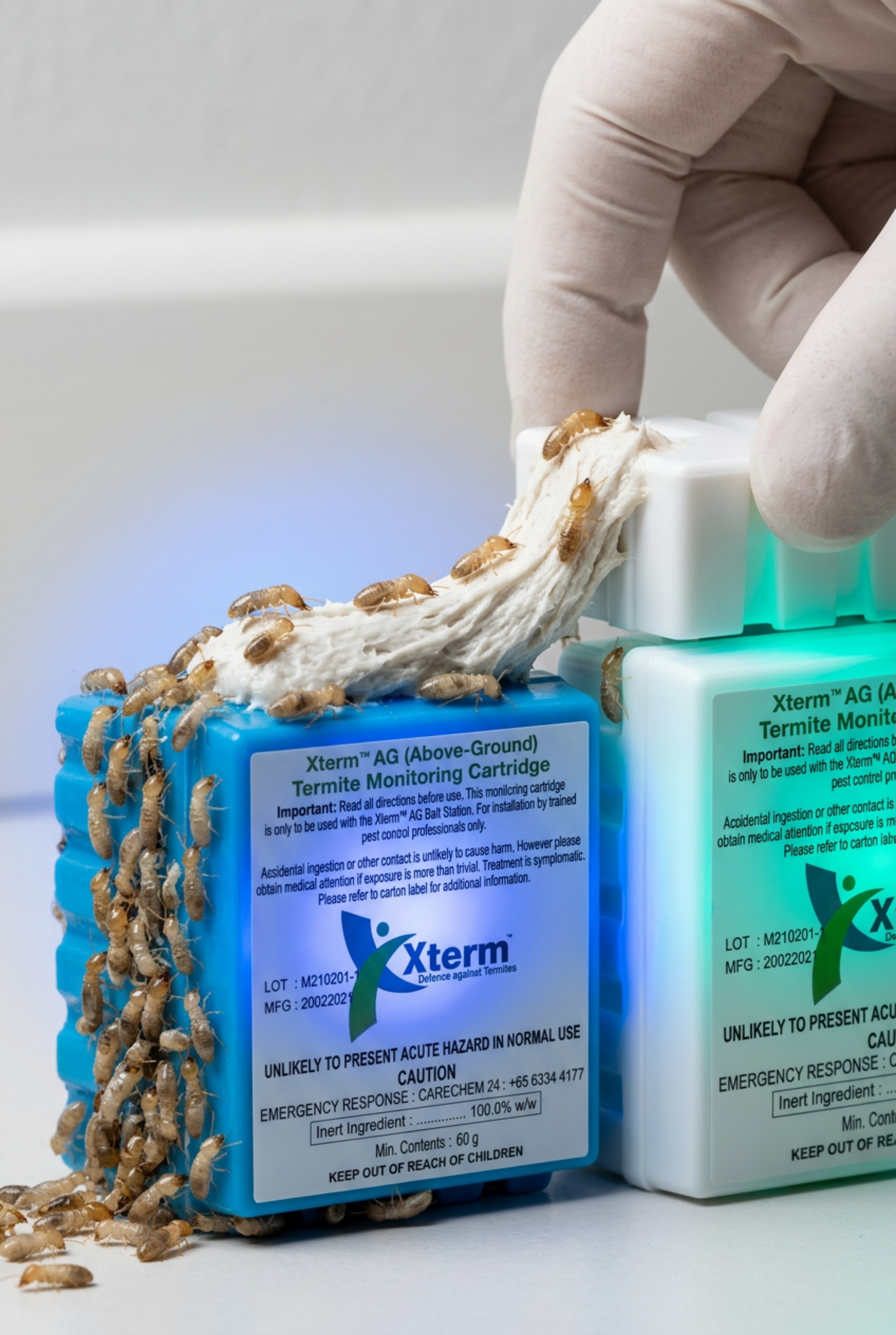 Close-up of blue Sumitomo Xterm Monitoring Cartridge used for termite detection and attraction in an AG station.