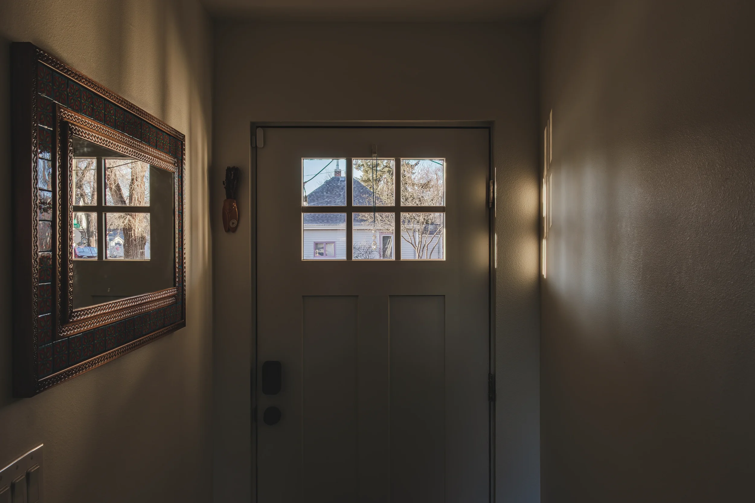 Interior design photography of a welcoming home entryway with natural light pouring through the front door window, shot in Berthoud, Colorado by Context Images.