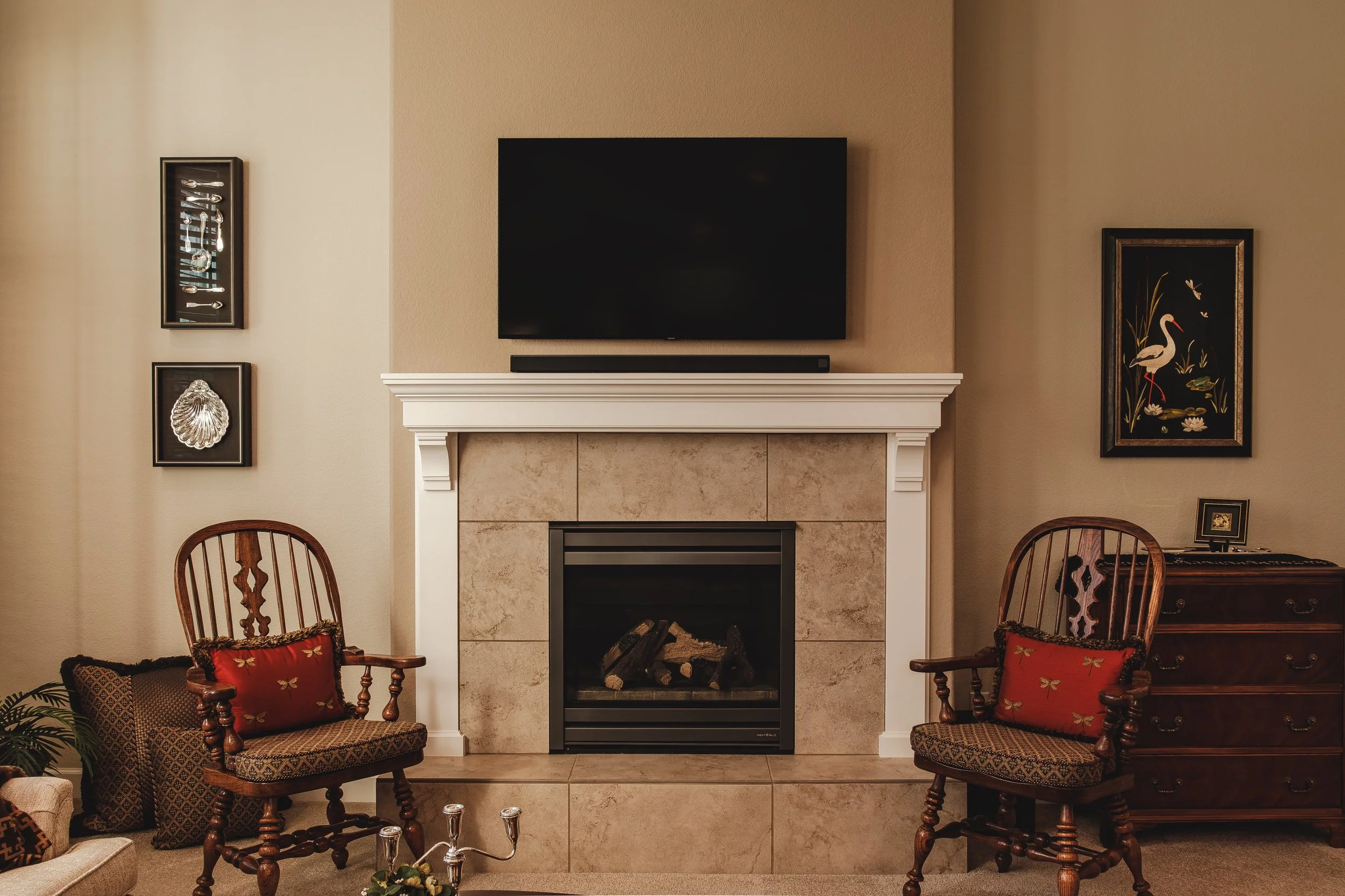 Interior design photo of an elegant living room with fireplace, traditional wooden chairs, and rich textures on fabric surfaces, taken in Longmont, Colorado by Context Images.