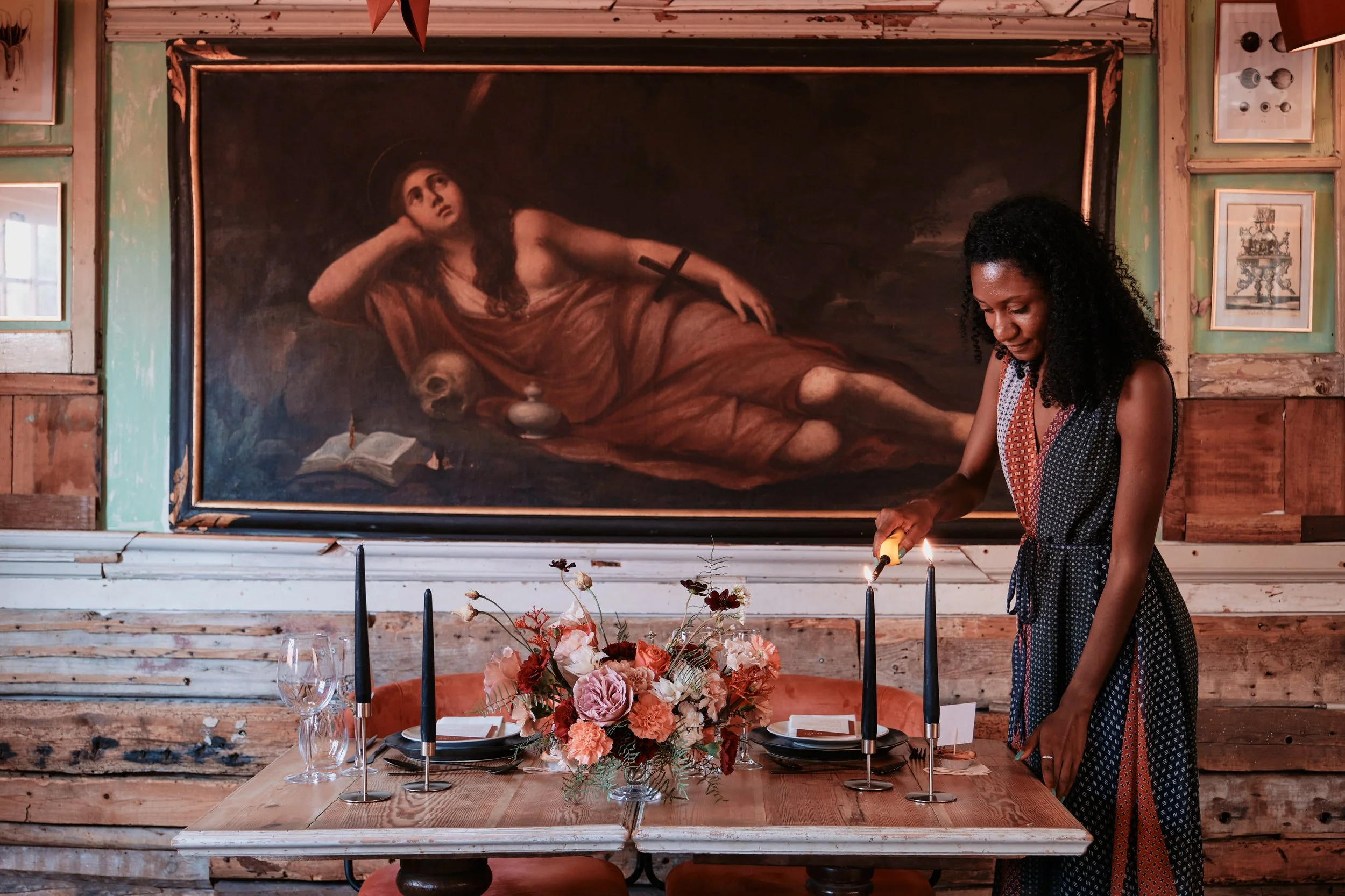 Destination wedding planner Olivia de Santos lighting a candle on a styled wedding table