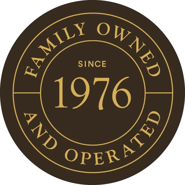 Gold and black circular emblem with text indicating the business is family owned and operated since 1976.