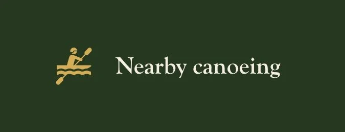 A green sign with a yellow icon of a person canoeing and the words 'Nearby canoeing' in white.