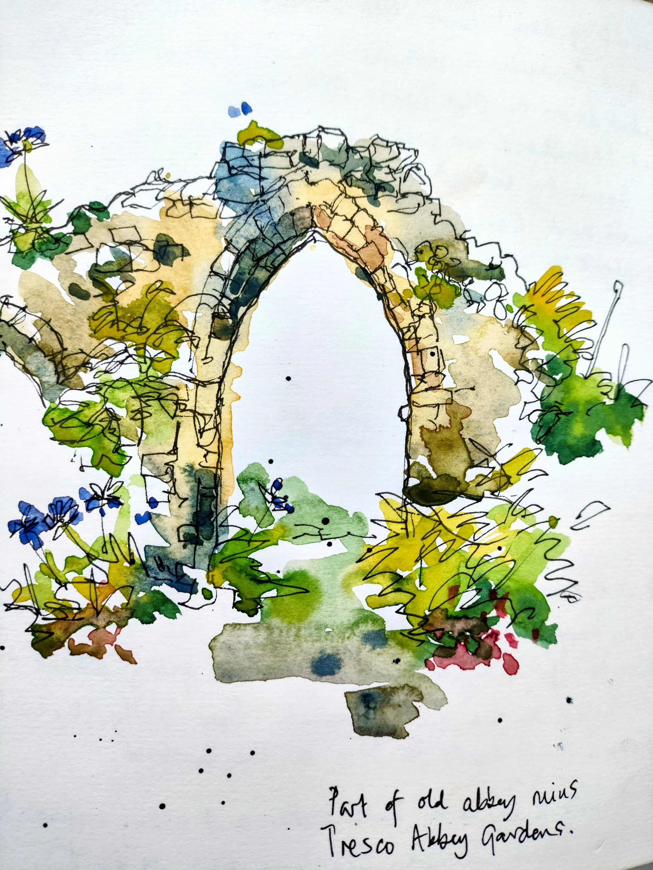 A watercolor painting of an archway - abbey ruins in Tresco Abbey Gardens made of old bricks, surrounded by greenery, with wildflowers around the base. There is handwritten text at the bottom that reads 'Part of old Abbey ruins Tresco Abbey Gardens.'