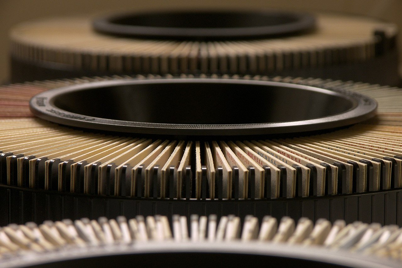 Close-up of a circular saw blade resting on a stack of corrugated cardboard.