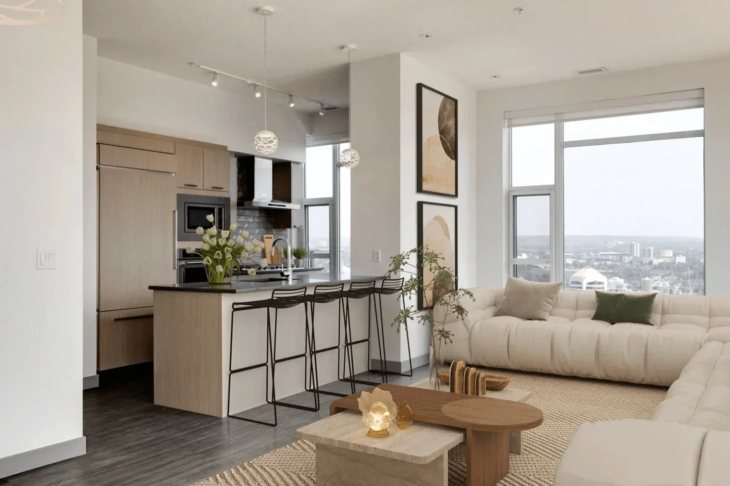 Modern open-concept living room and kitchen with minimalist decor, bar stools at the kitchen island, large windows showing city views, and artwork on the walls.