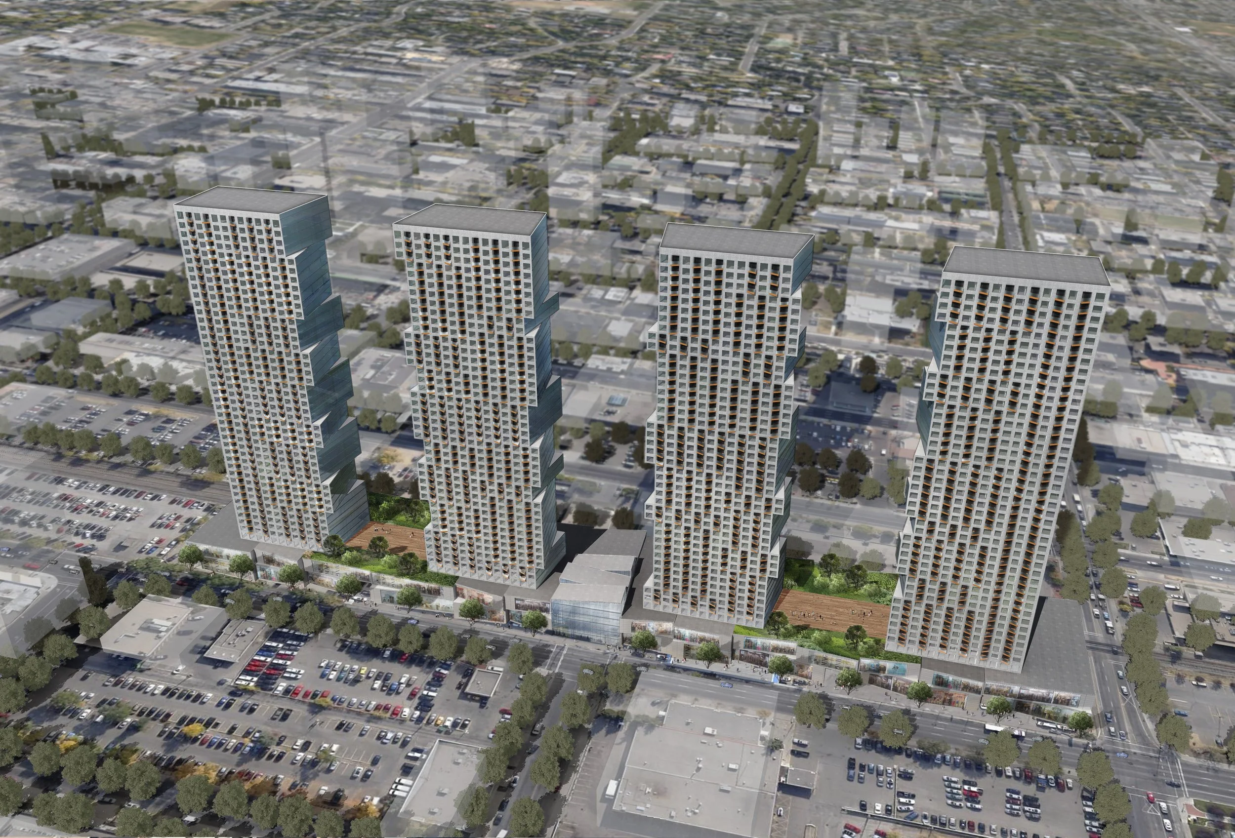 Aerial view of four modern high-rise residential buildings with green spaces and parking lots in an urban area.
