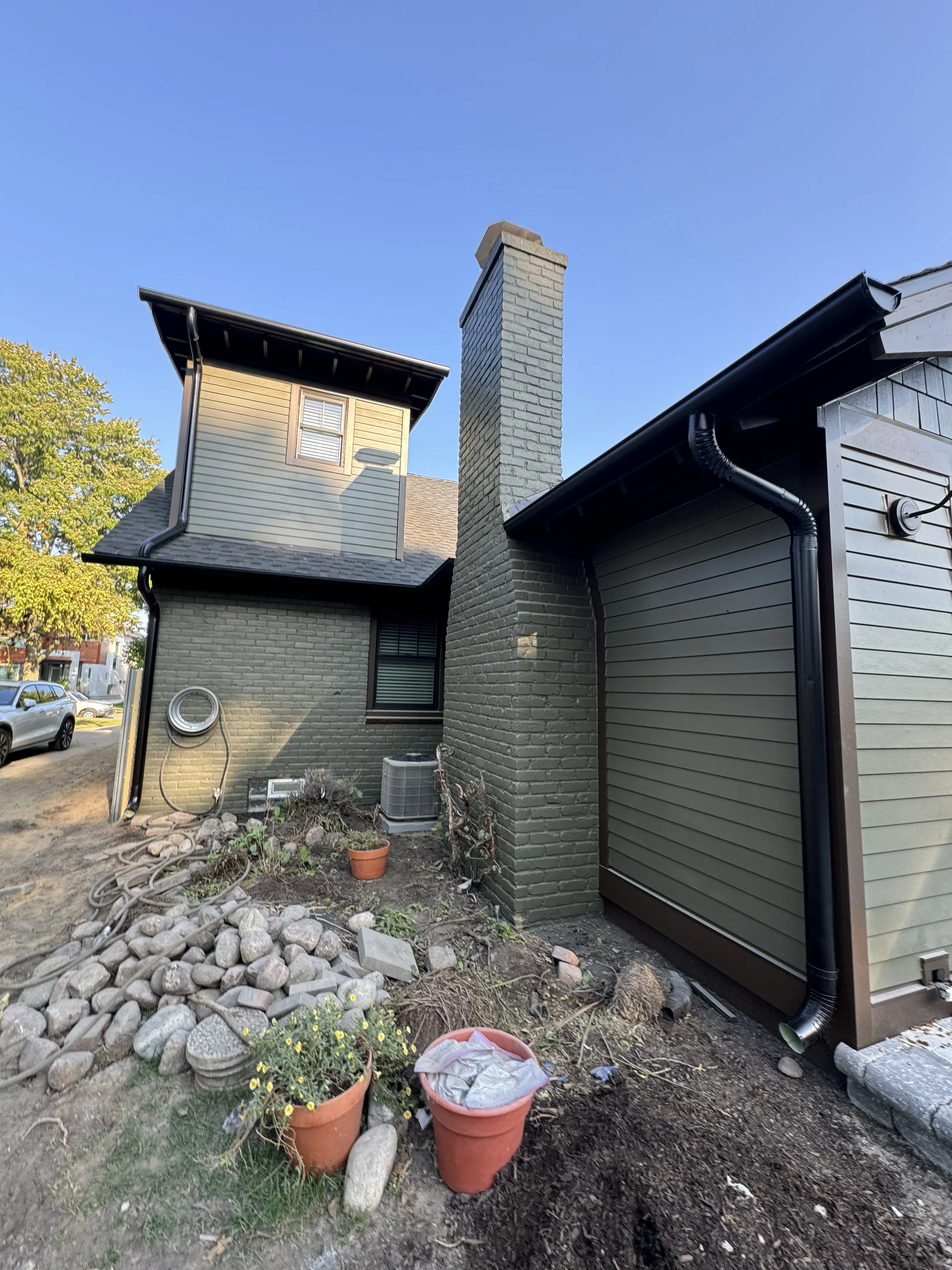 Backyard of a house with a brick exterior, called dads seamless gutters for new seamless black k-style gutters in michigan