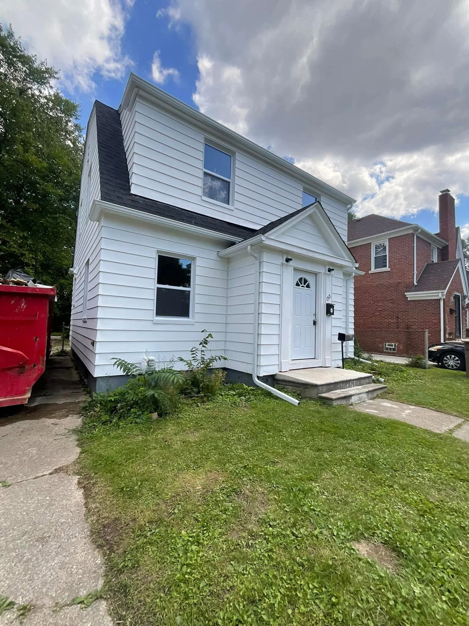A white two-story house hired dads seamless gutters to remove and install new white seamless gutters in detroit michigan