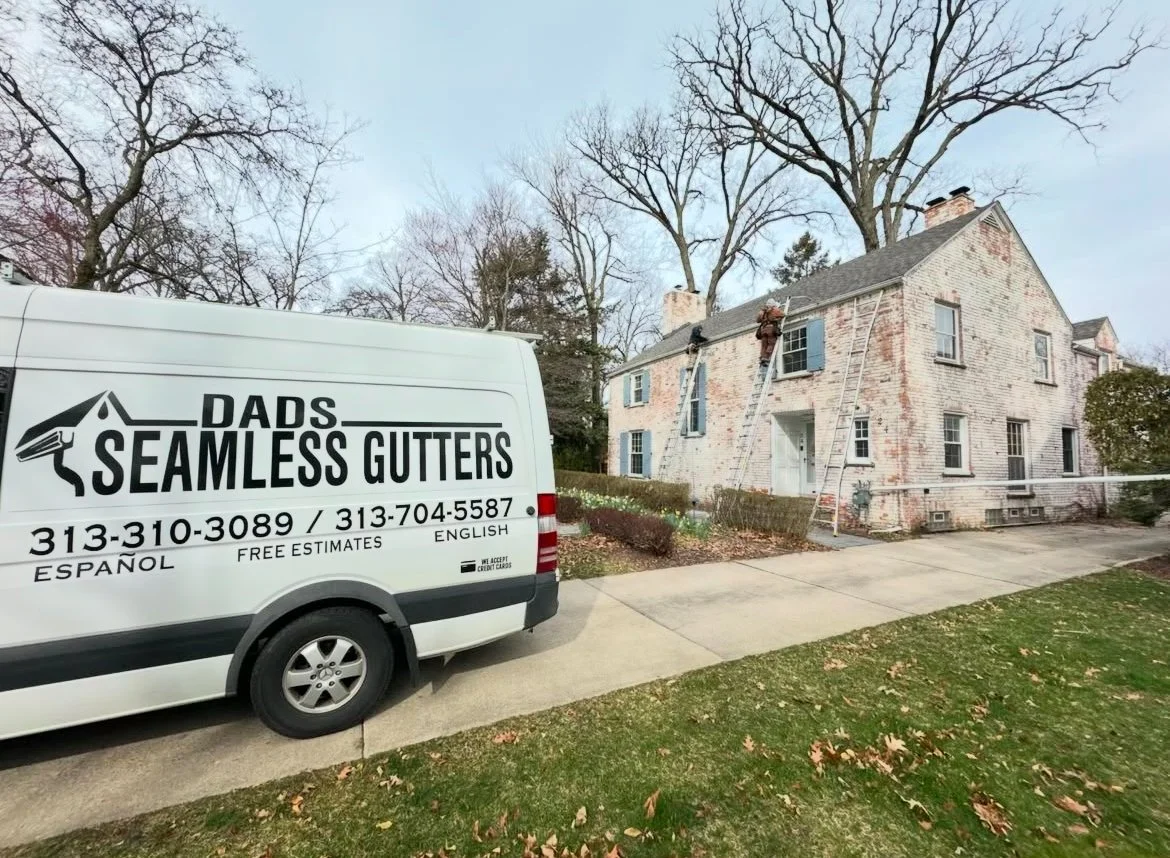 workers installing copper tone seamless gutters 5' on a beautiful home with a truck parked nearby labeled "Dads Seamless Gutters."
seamless gutters