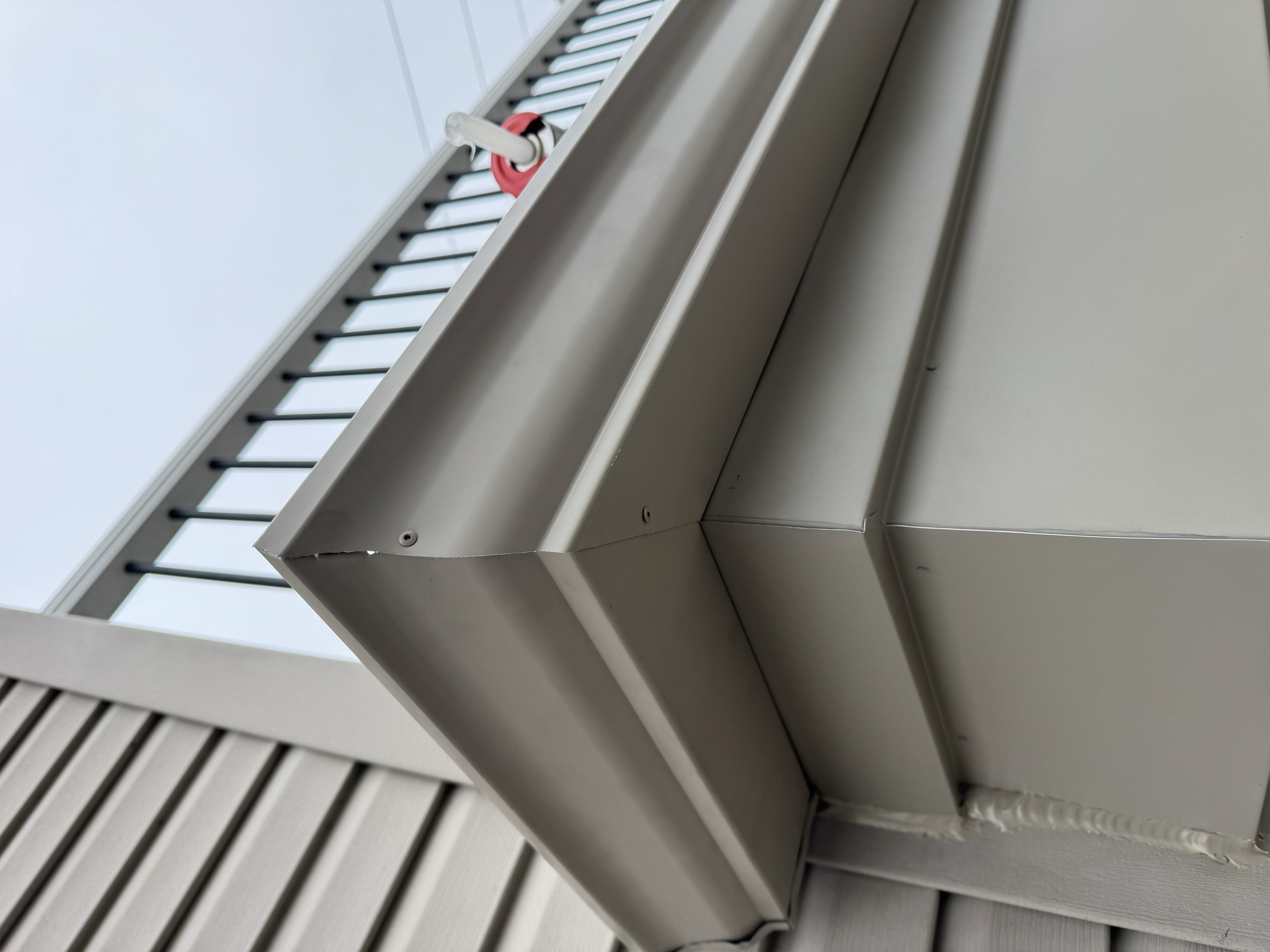 A close-up view of a beige seamless gutters installed by dad's seamless gutters. custom gutters installed on a new addition to home in macomb,michigan