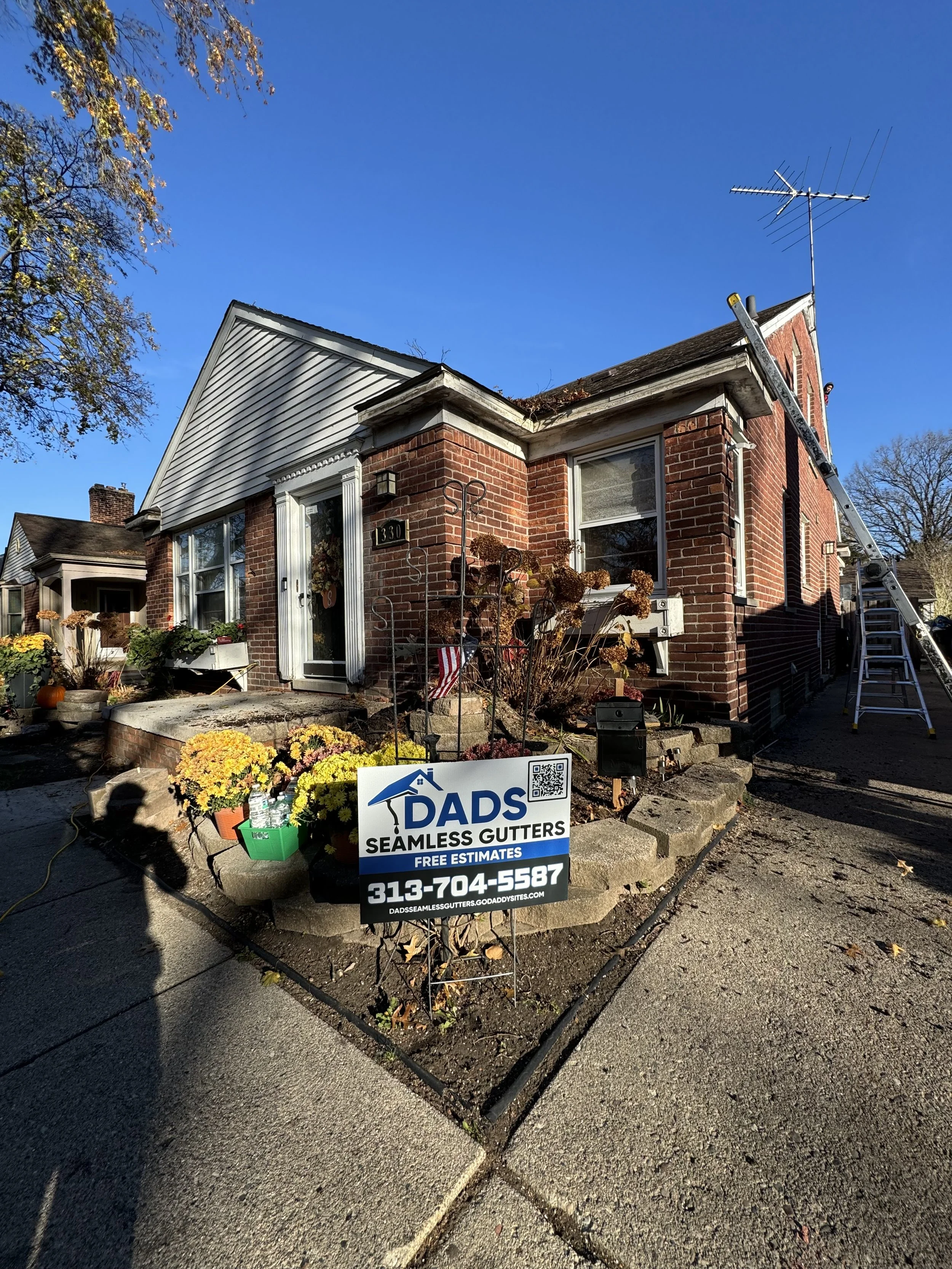 A brick house with a front porch Allen park Michigan installed clay gutters first time home buyer trusting dads seamless gutter with 5' gutters installed