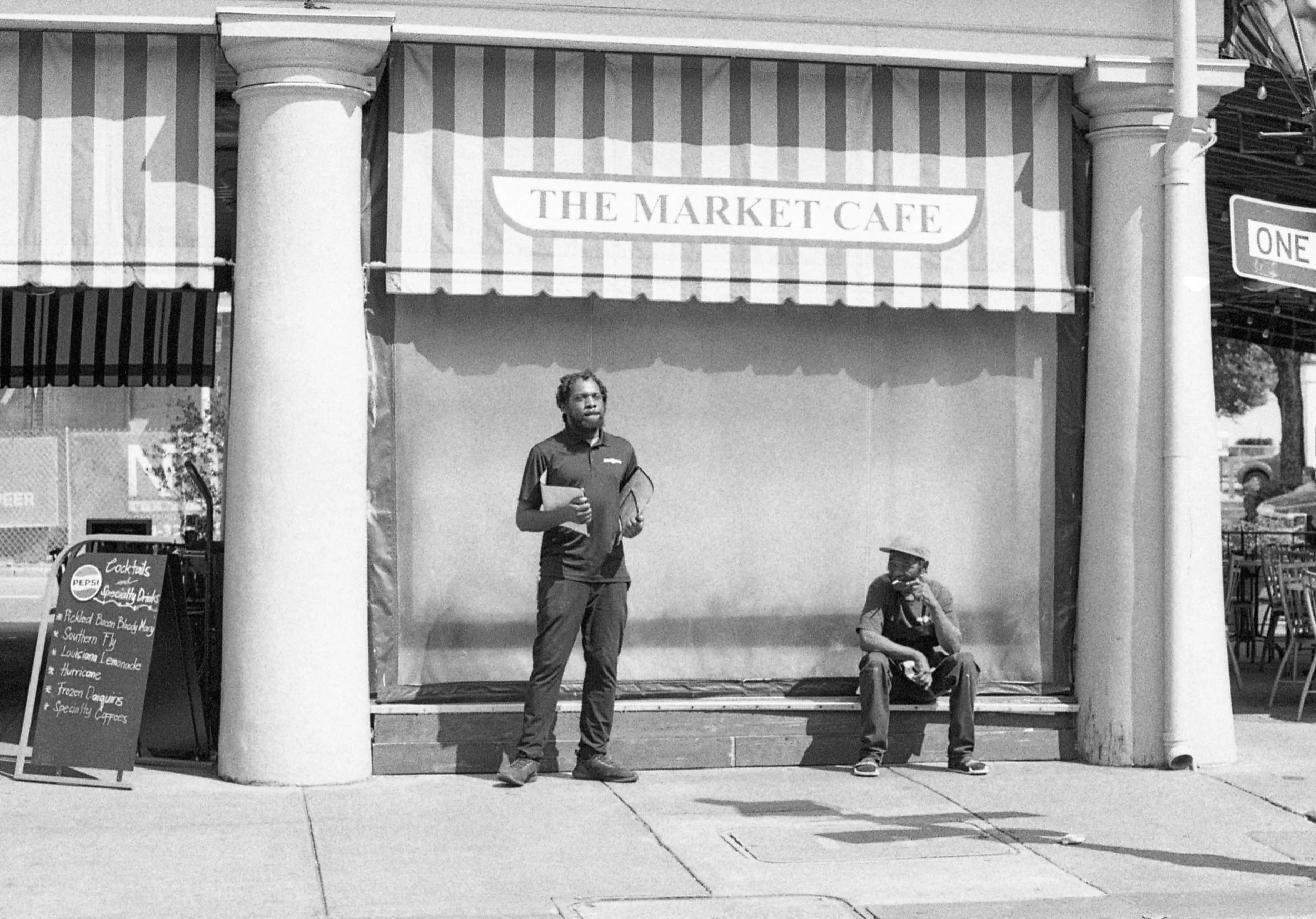 Two men, one an employee, seen outside of The Market Cafe in the historic New Orleans on Decatur St.