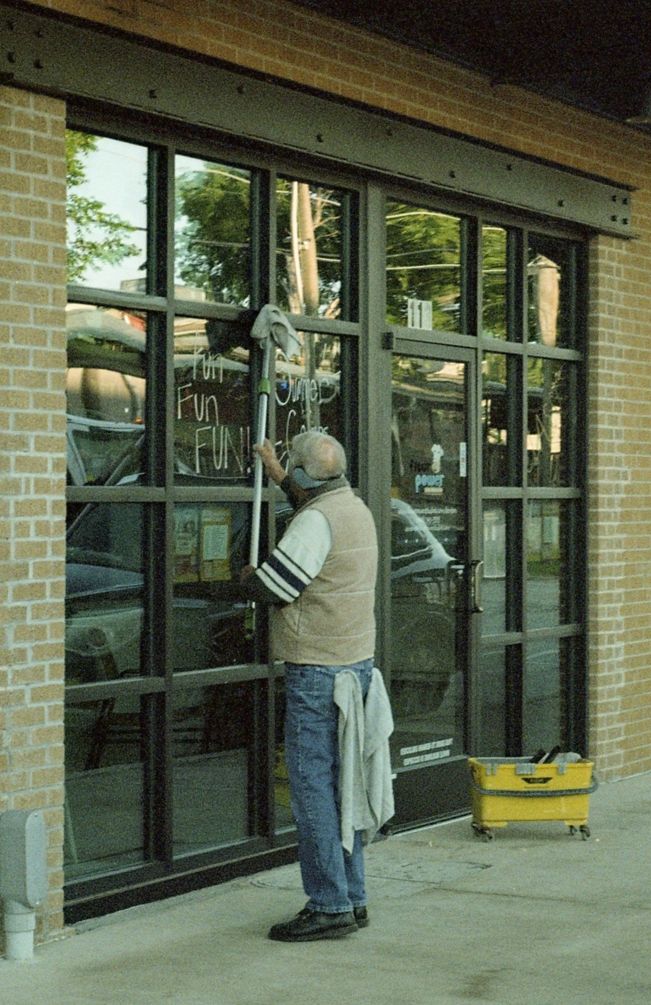 There's irony in this photo, because you see a worker washing windows and on the windows is an advertisement announcing "Fun Fun Fun"