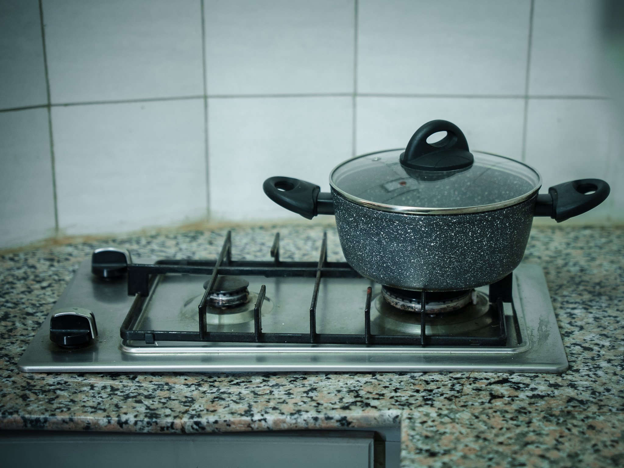 Kitchenette at Quality INN Hotel Kigali, Rwanda, with gas stovetop and cookware for self-catering guests.