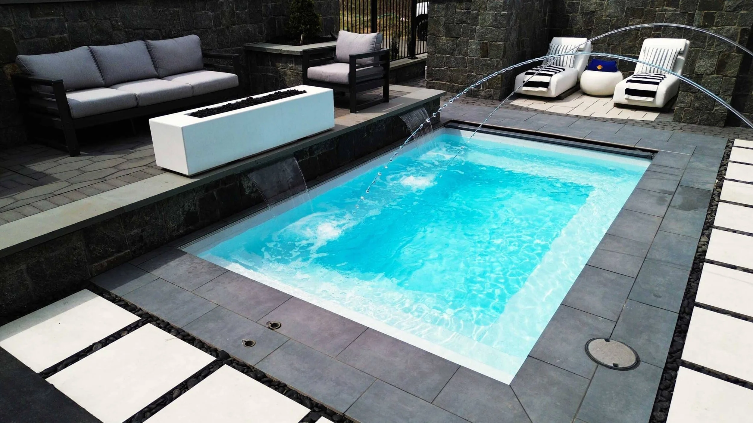 Inground plunge pool with water fall and fire table