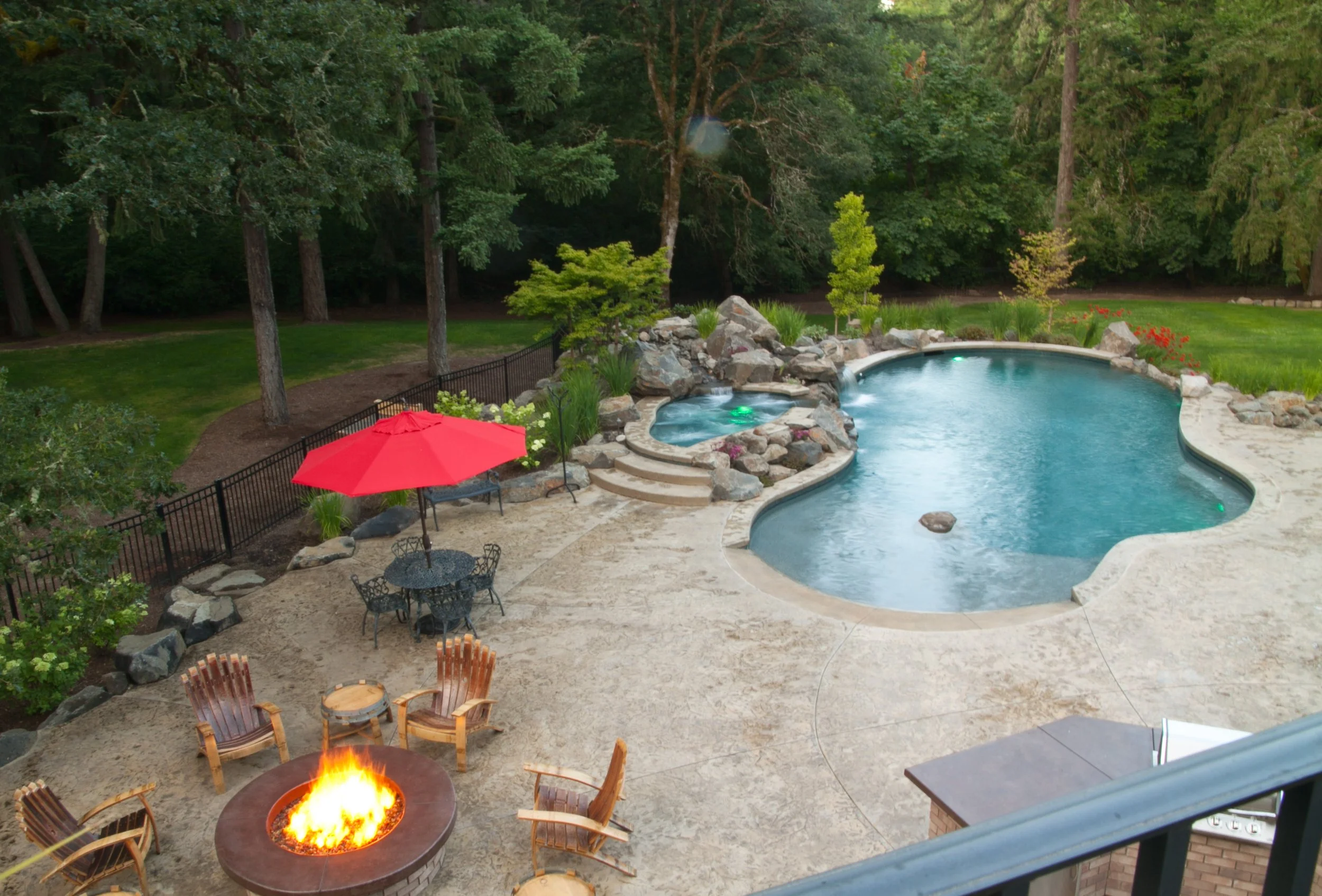 Inground pool with stamped cement patio and fire pit