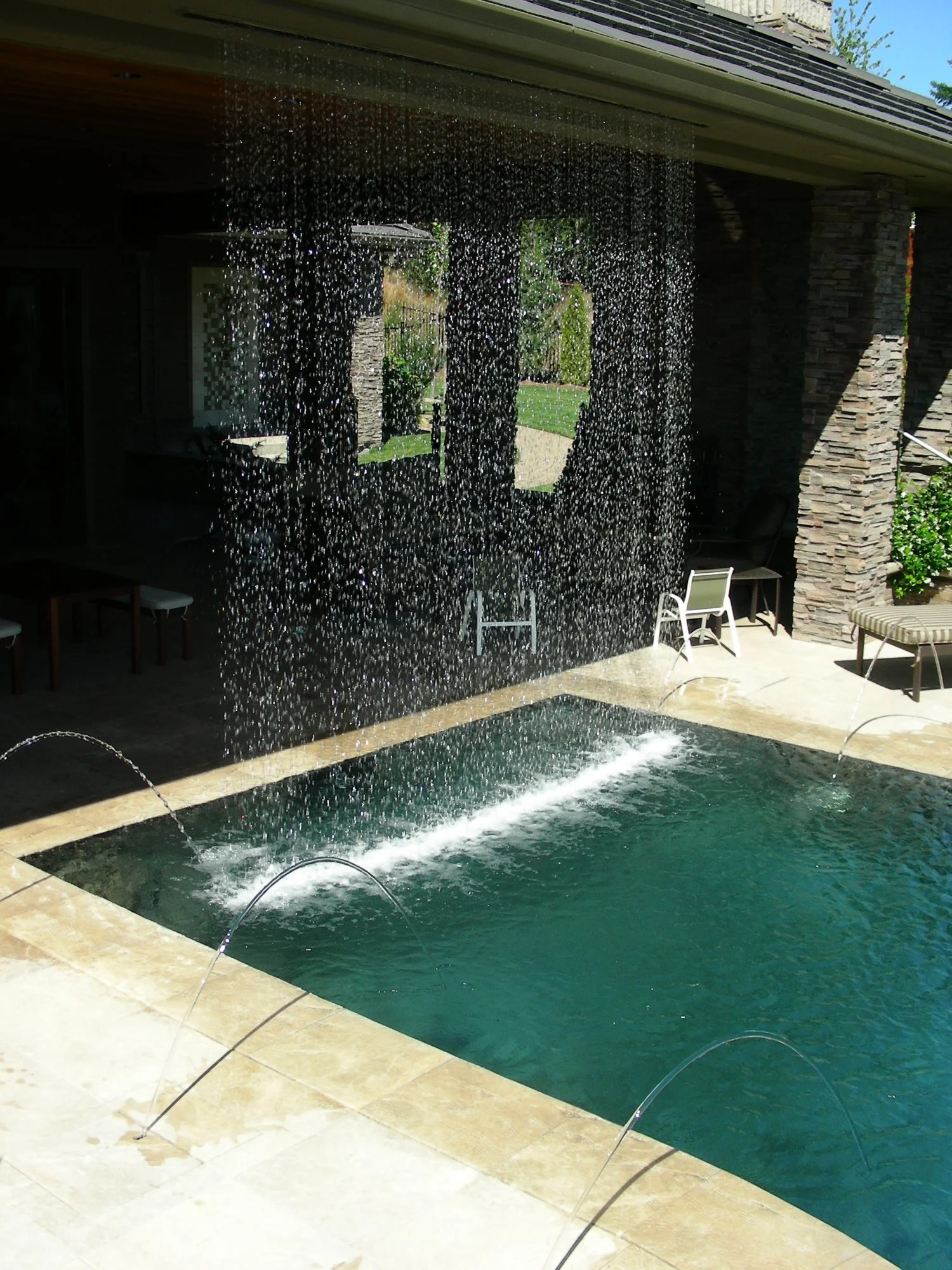 Inground pool with waterfall and integrated fountains