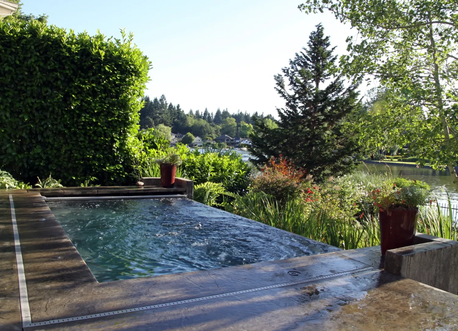 Pool remodeling services in WEst Lynn, OR showcasing a renovated inground pool with new coping, lighting, and surrounding landscape design
