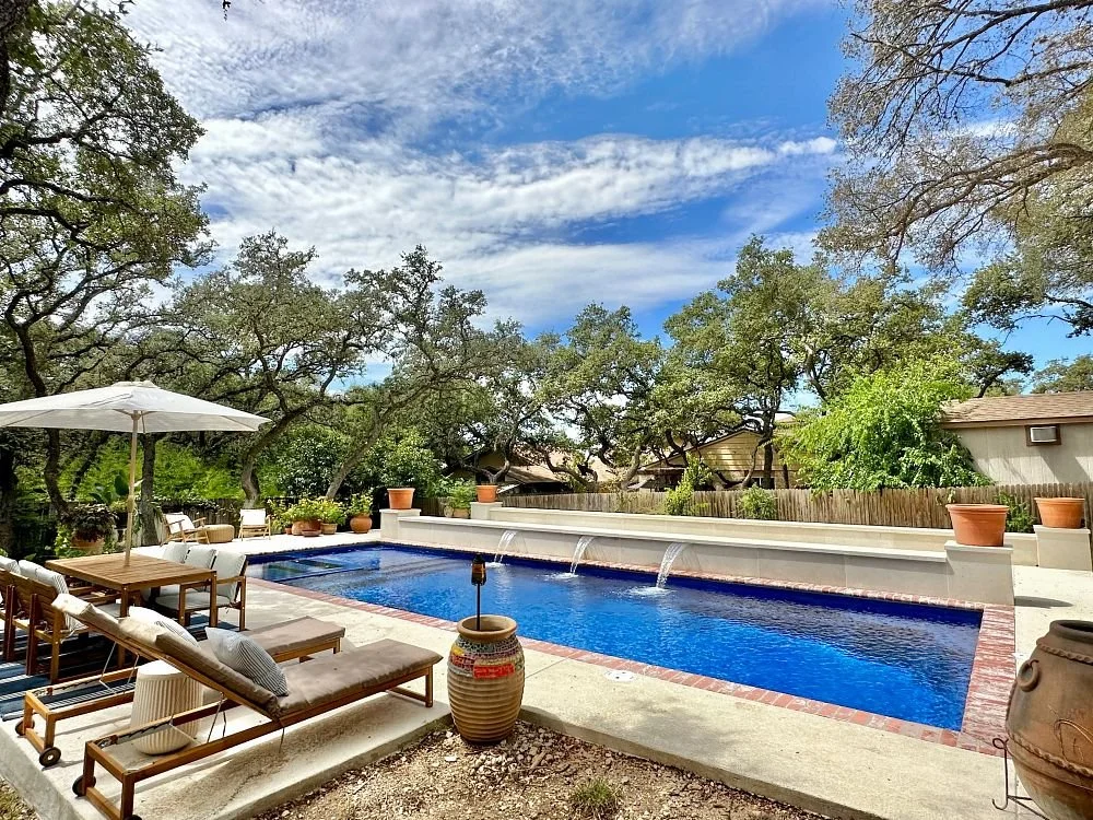 Inground pool with concrete patio, retaining wall, and waterfalls