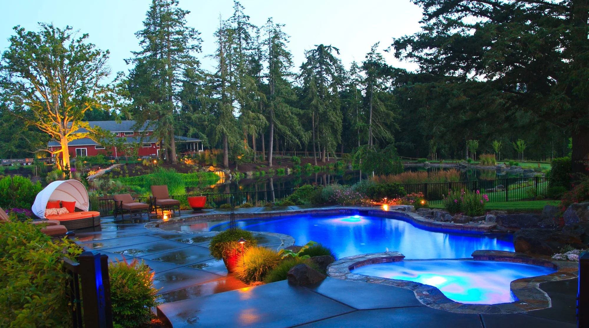 Gorgeous outdoor living space with pool, spa, outdoor lighting, and plantings