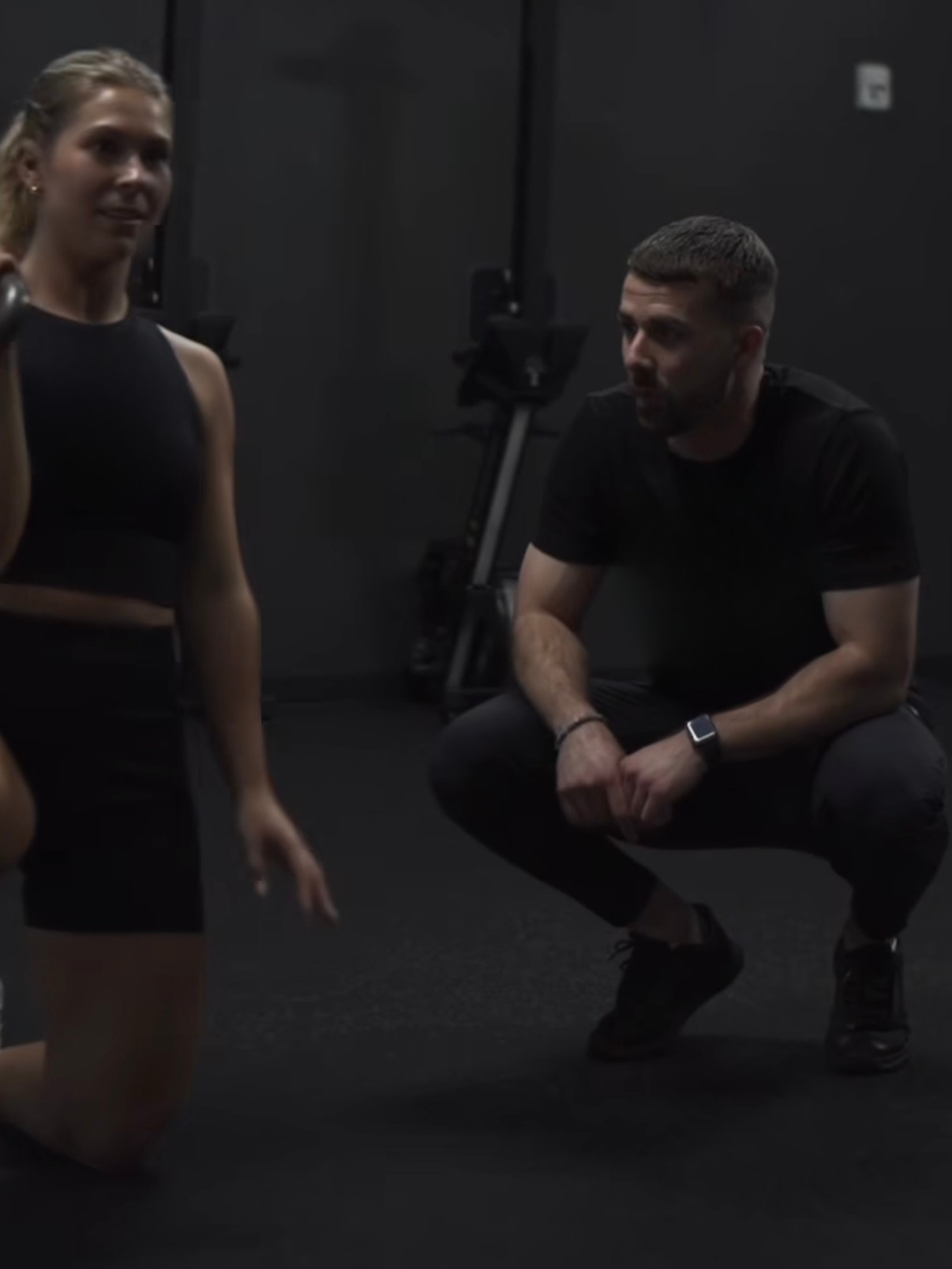 Personal trainer coaching a client through a squat in Plaza Midwood Charlotte NC