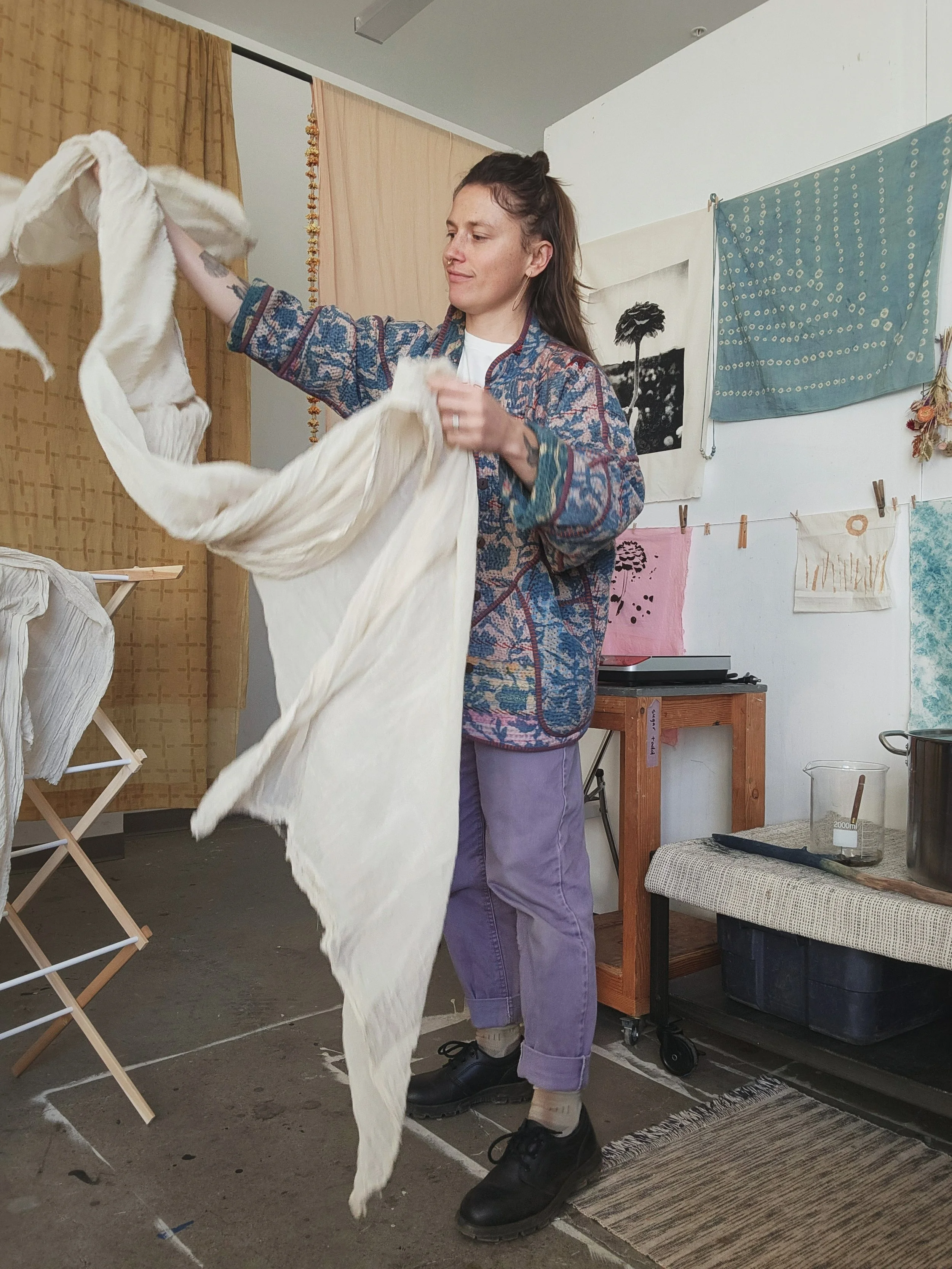 sugar todd in her studio, tossing a length of cotton textile
