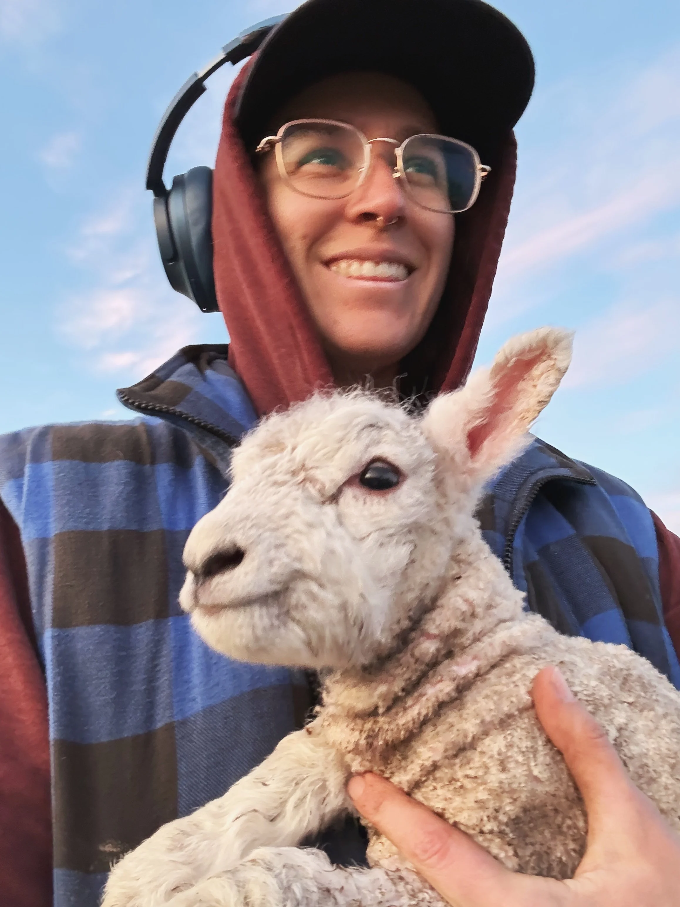 Charli Beck grinning and holding a lamb