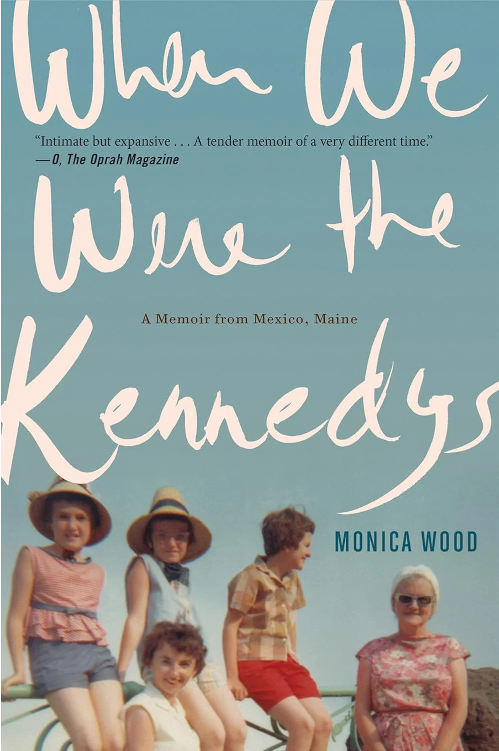 Book cover titled 'When We Were the Kennedys' by Monica Wood, featuring a color photo of five children and one older woman with short white hair, all wearing summer clothes and hats.