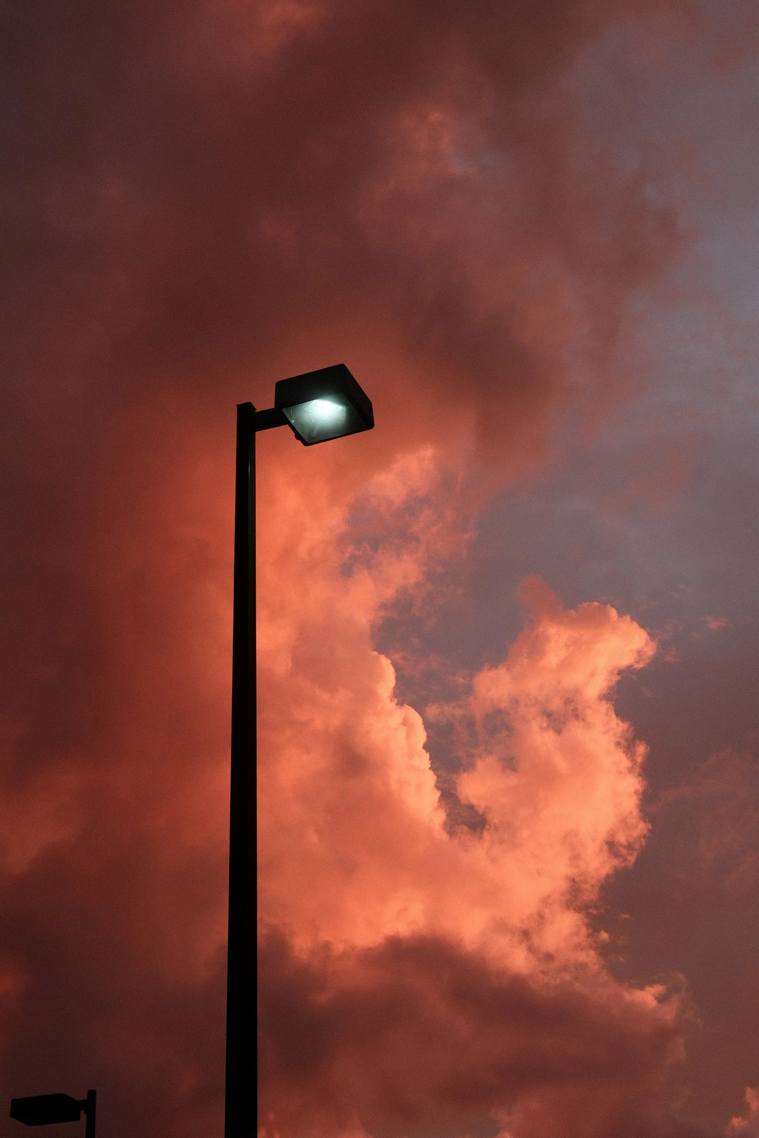 A streetlamp against a colorful sunset sky with pink and purple clouds.