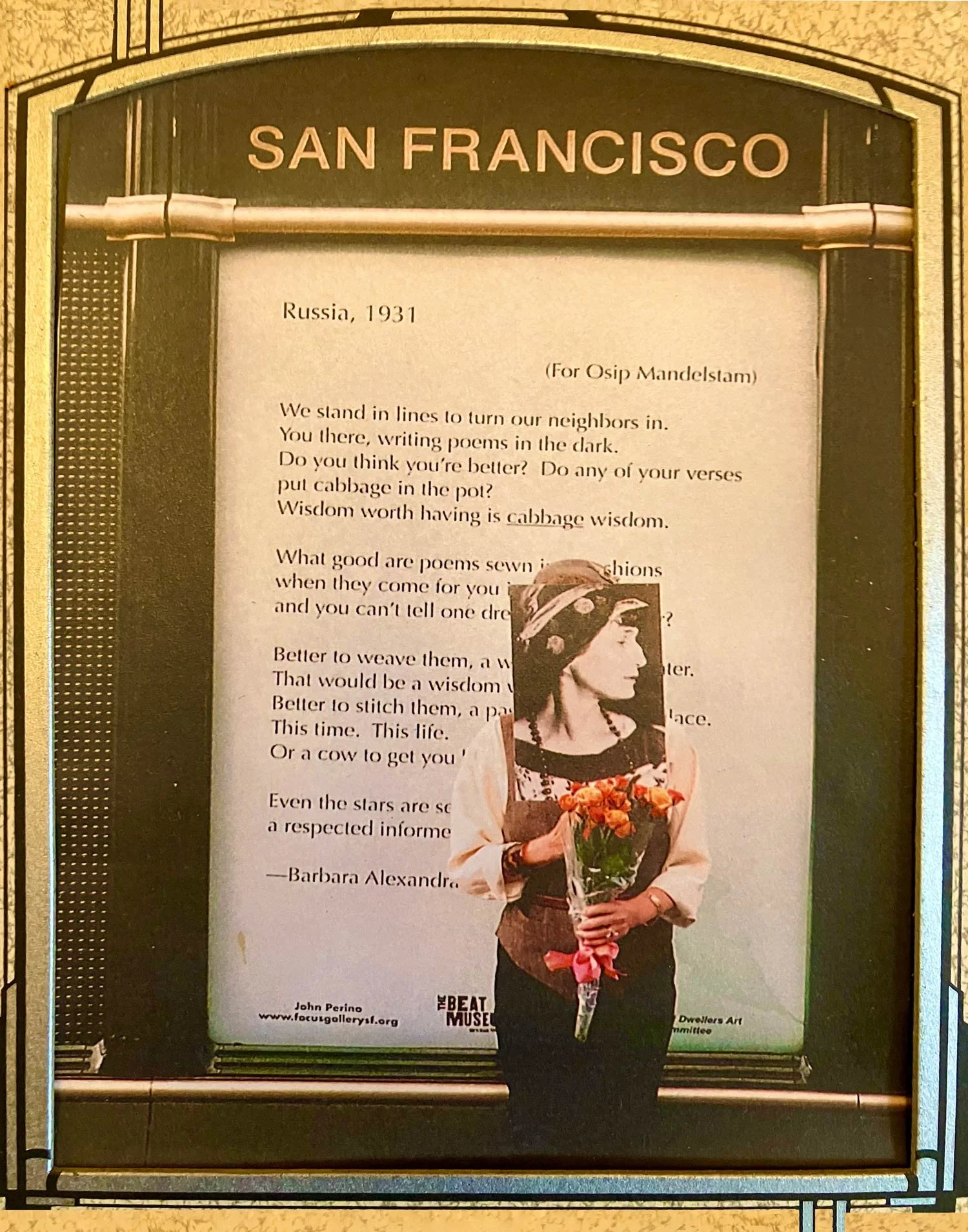 BAS (as Anna Akhmatova) standing in front of kiosk billboard featuring one of her poems