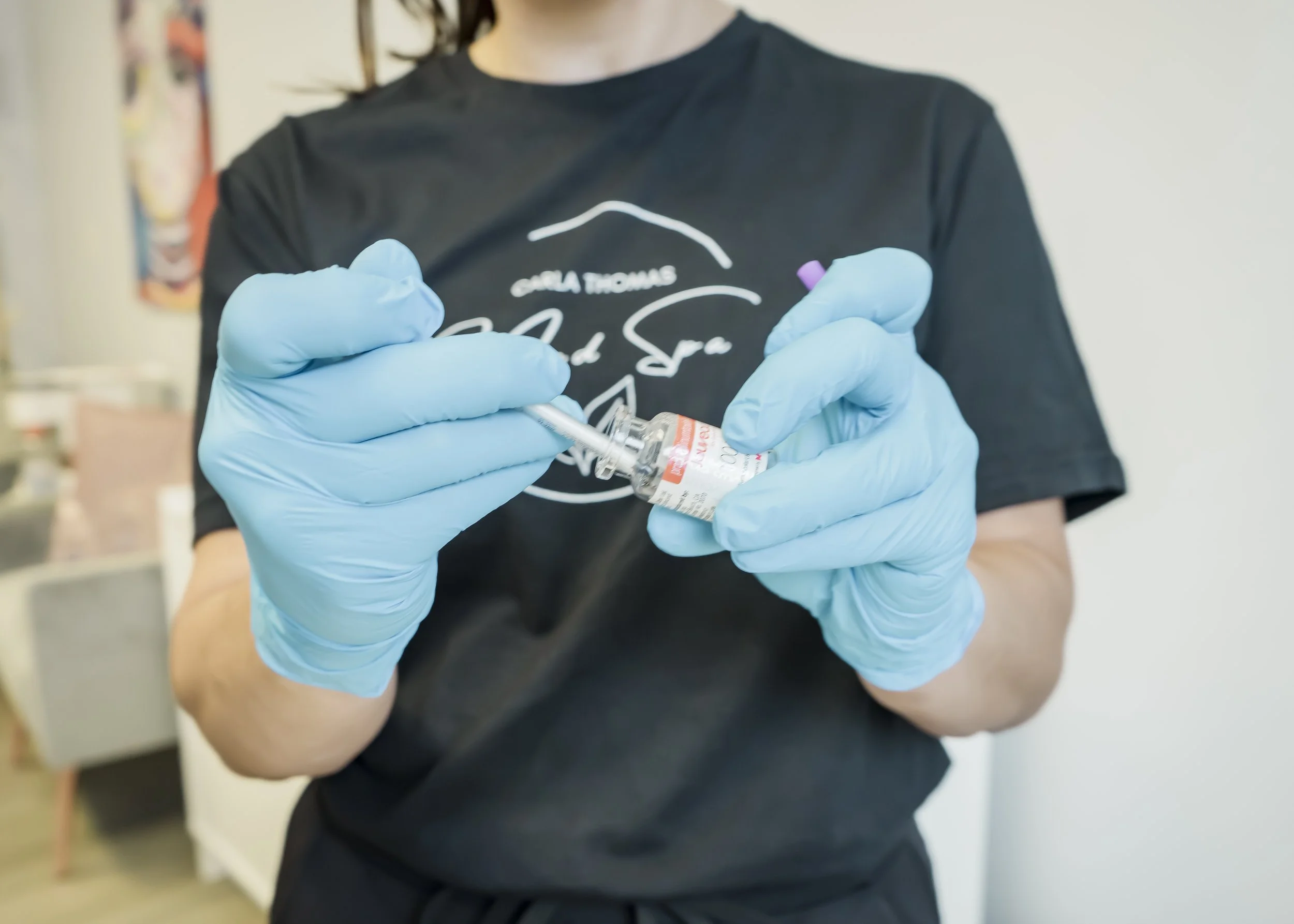 Nurse practitioner wearing blue gloves preparing a Jeuveau injection at Carla Thomas Med Spa