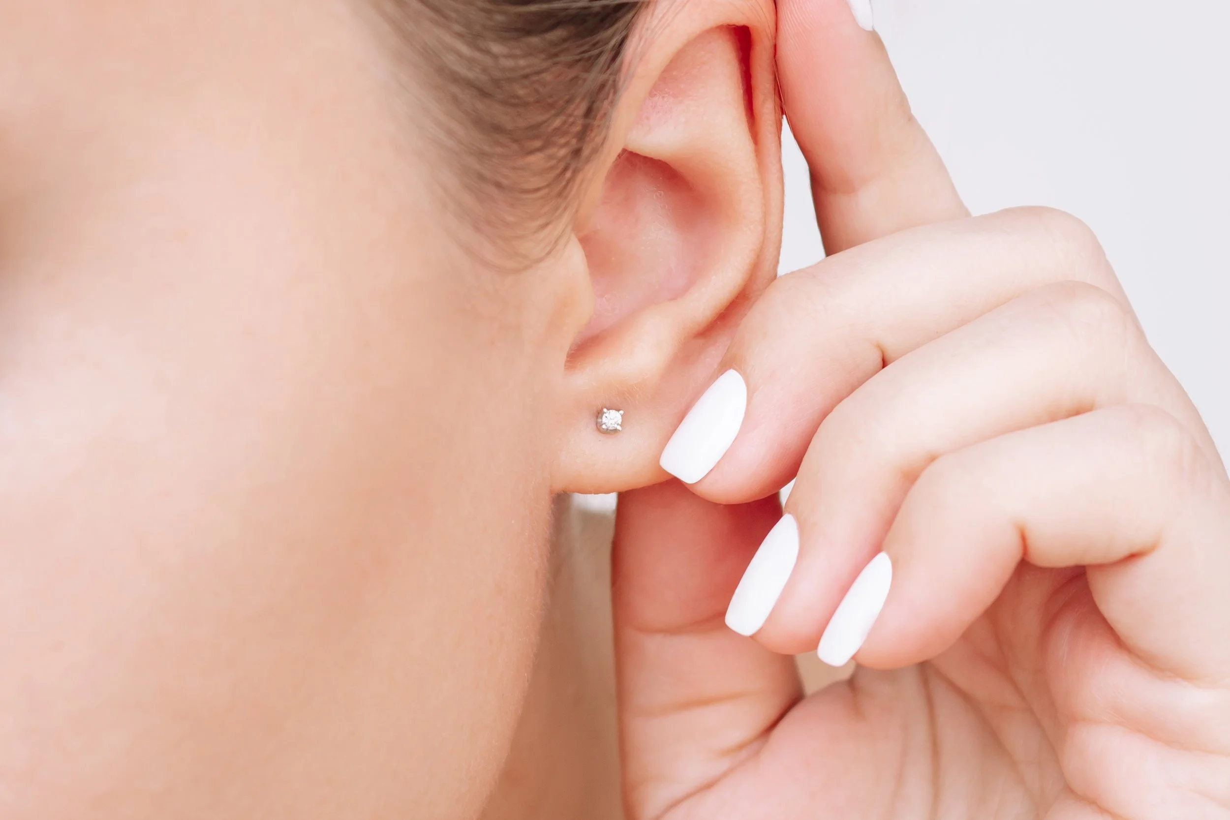 Professional earlobe piercing with a diamond stud earring by a nurse practitioner in La Grange, IL.