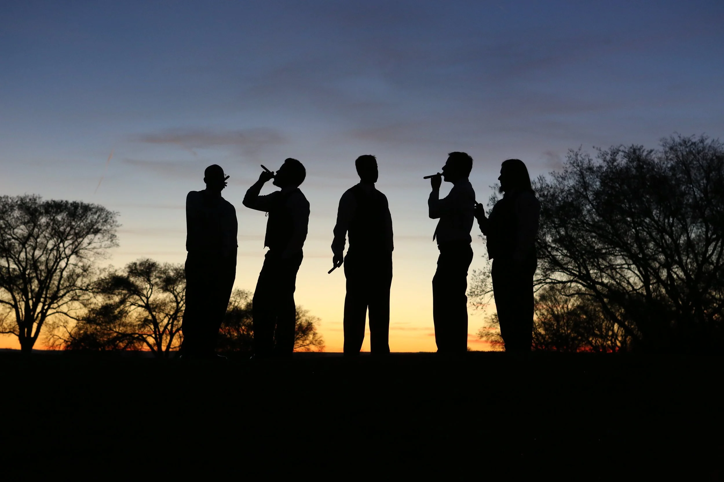 Silhouette of Groomsmen celebrating with a cigar at sunset.JPG