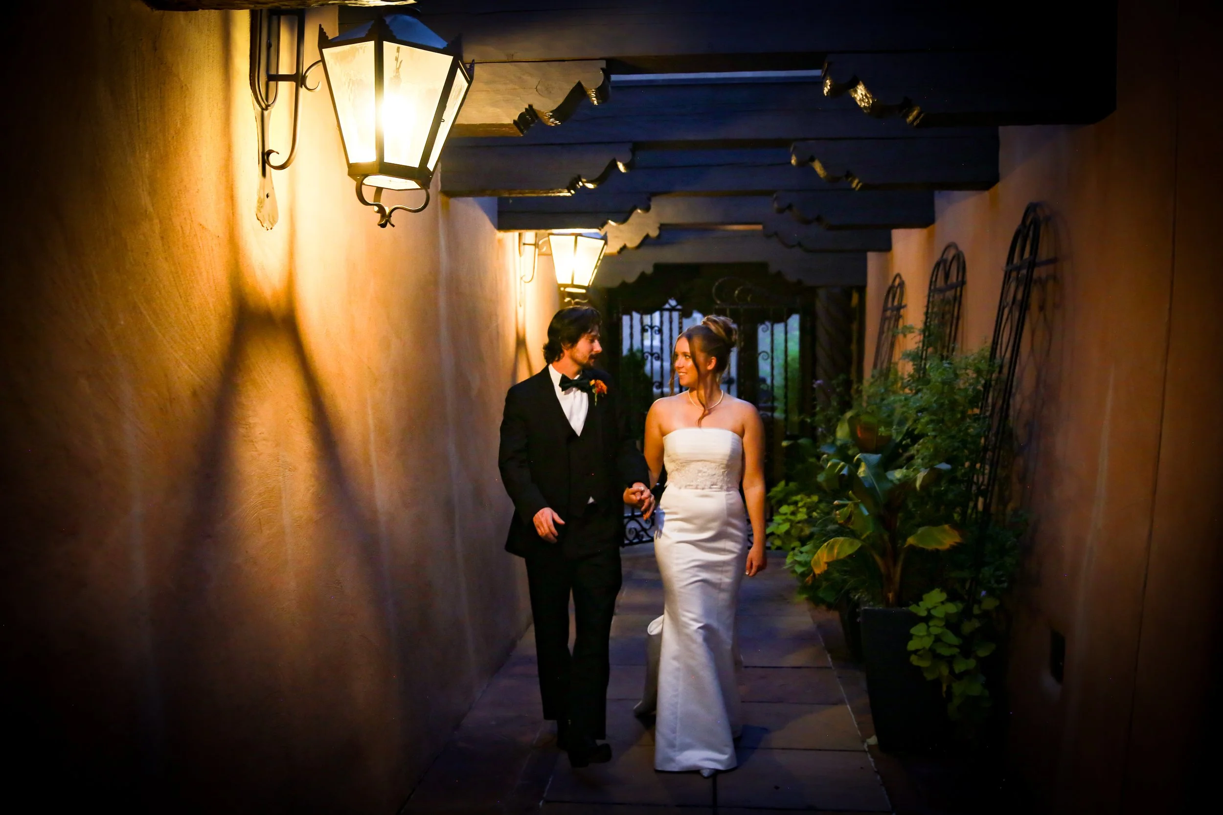 Couple take a stroll during their reception at the La Fonda on the Plaza under their beautiful night lights