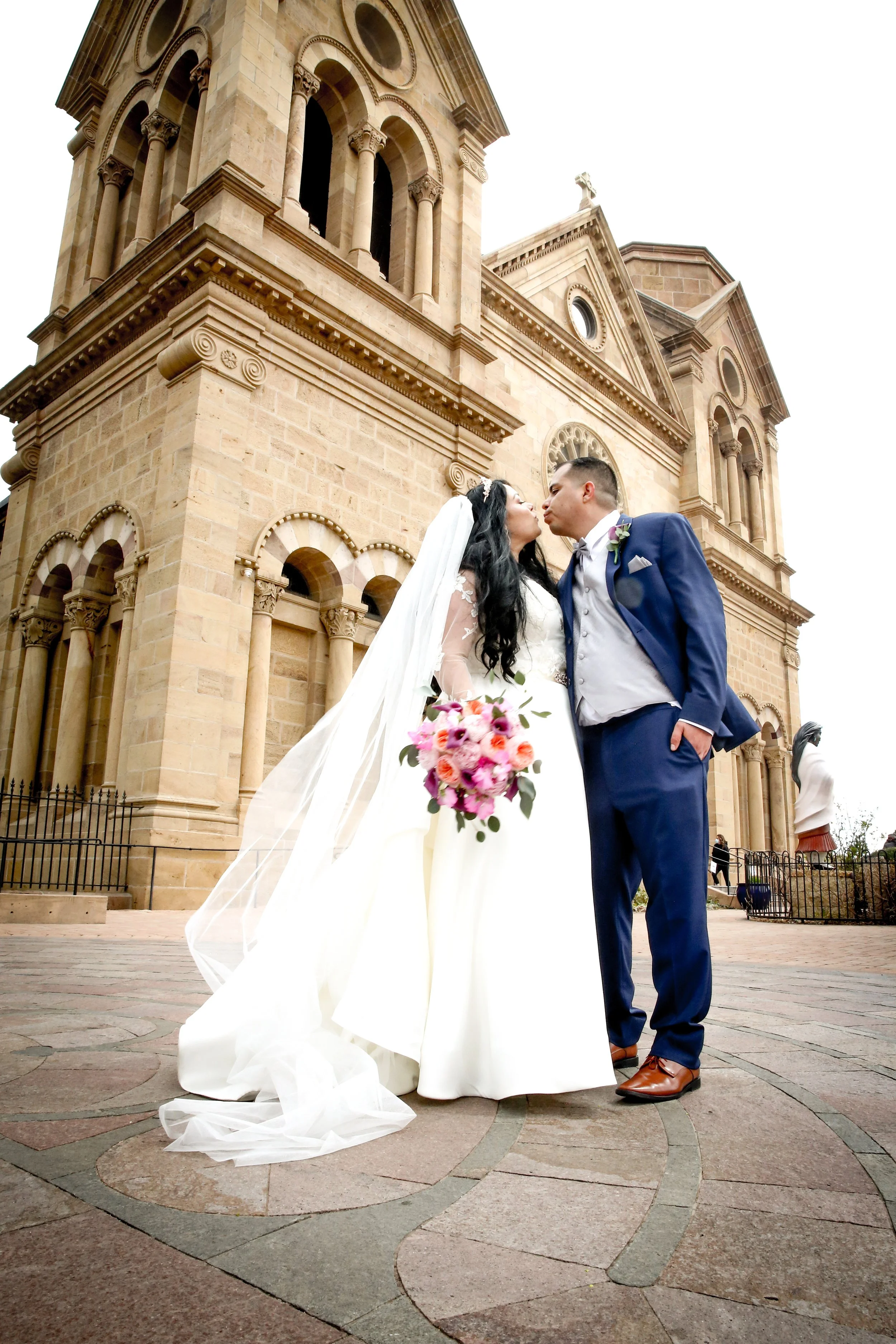 Newlyweds kiss in front of the iconic St Francis Cathedral in Santa Fe New Mexico