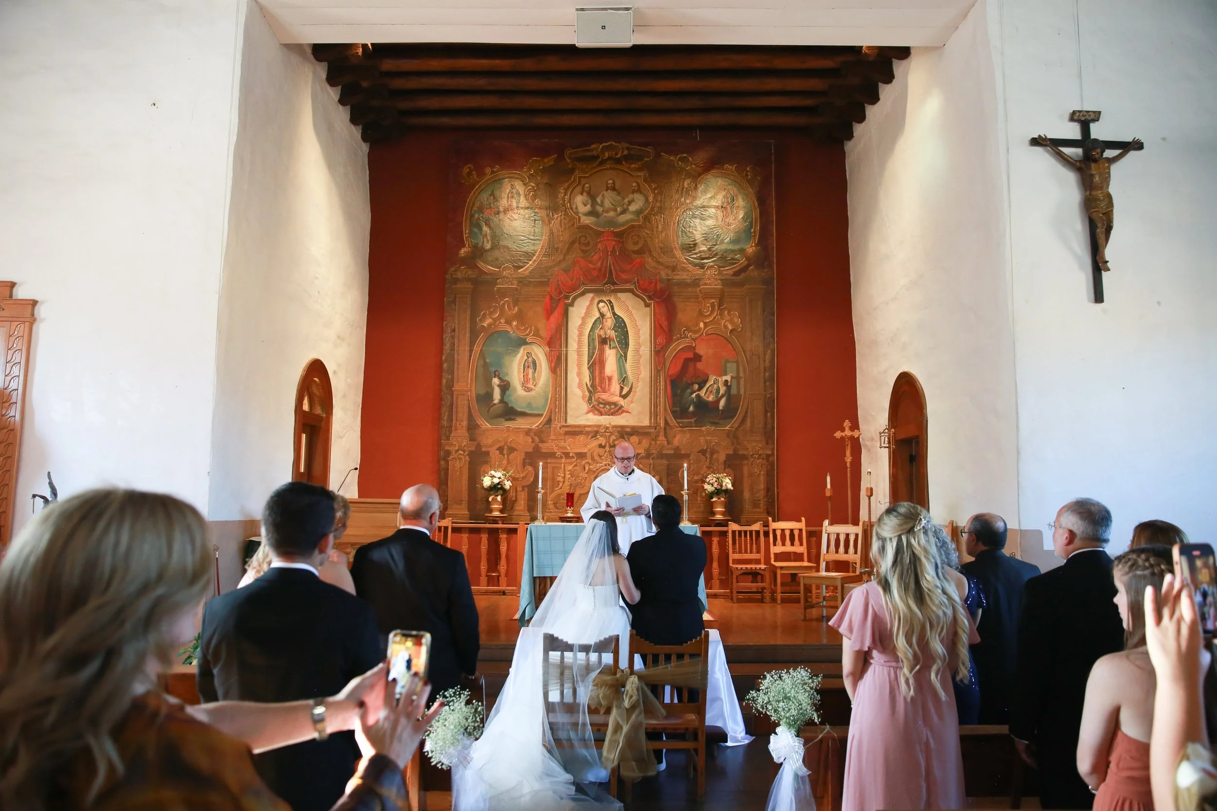 A couple listens to the priest that is about to marry them at the Our Lady of Guadalupe Church in Santa Fe New Mexico