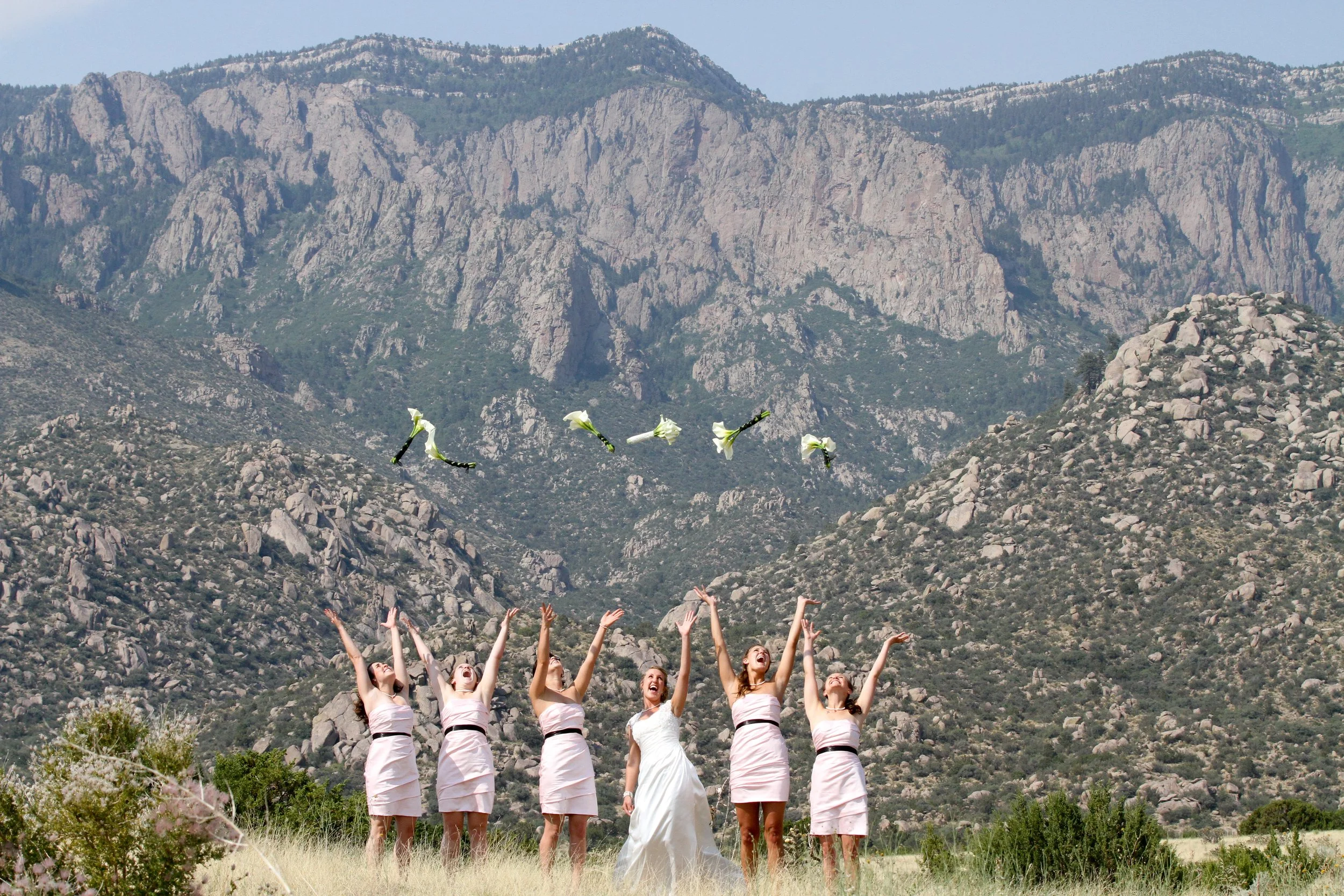 Bride and bridesmaids celebrating during a wedding in Albuquerque with the Sandia Mountains in the background