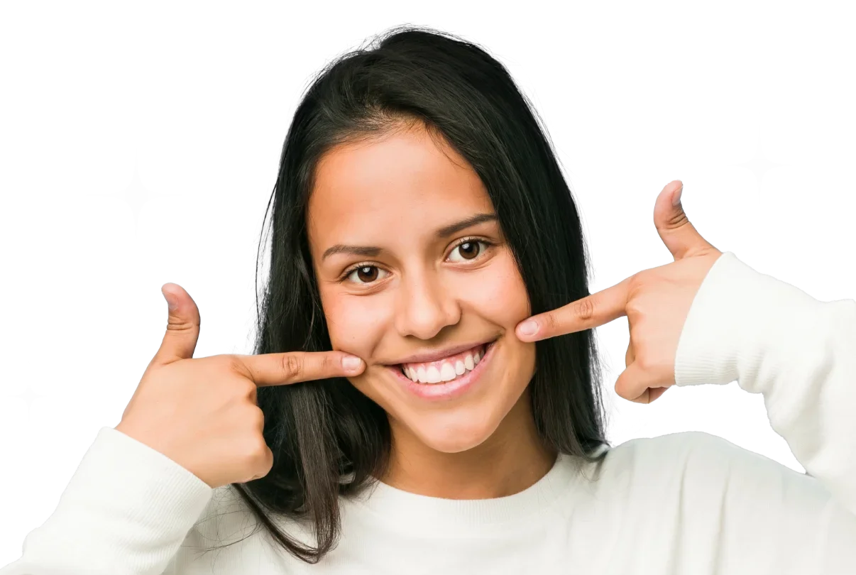 Une femme souriante pointant ses joues avec ses doigts, avec des étincelles en arrière-plan.