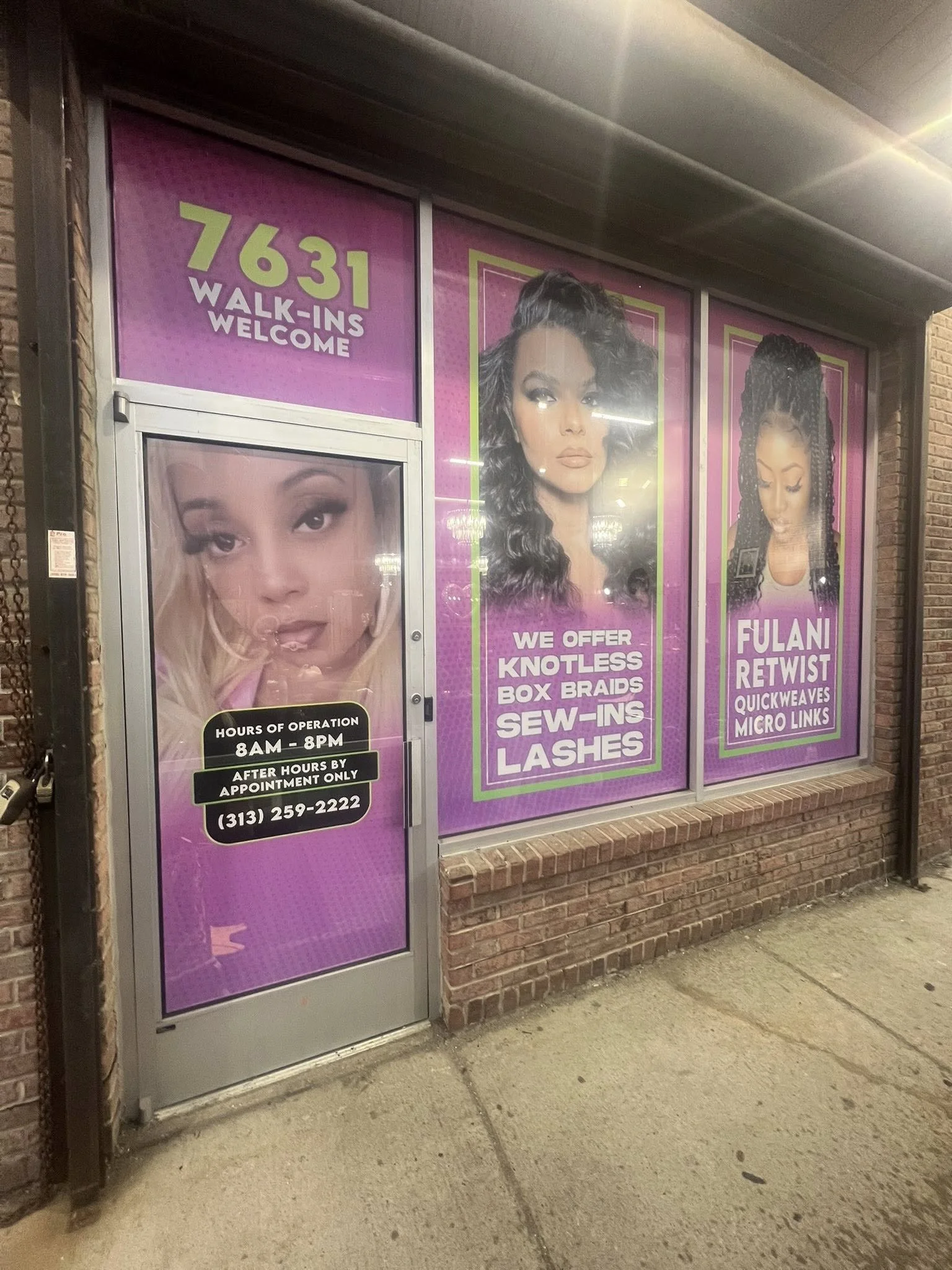 Storefront window advertising hair and eyelash services with images of women with various hairstyles and makeup, vibrant pink and purple background, and operational hours from 8 AM to 8 PM.