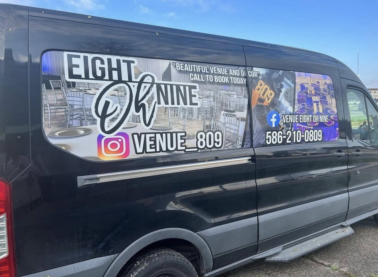 Side of a black van with advertising for Venue Eight Oh Nine, including social media icons, phone number, and images of the event space and DJ equipment.