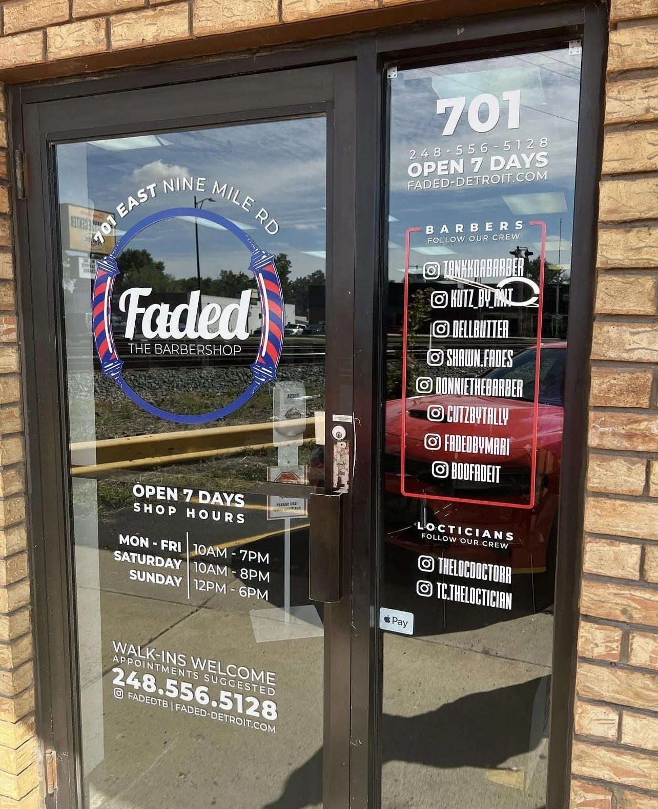 The glass door of Faded barbershop with store information, social media handles, and hours of operation written on the door. The shop is located on East Nine Mile Road.