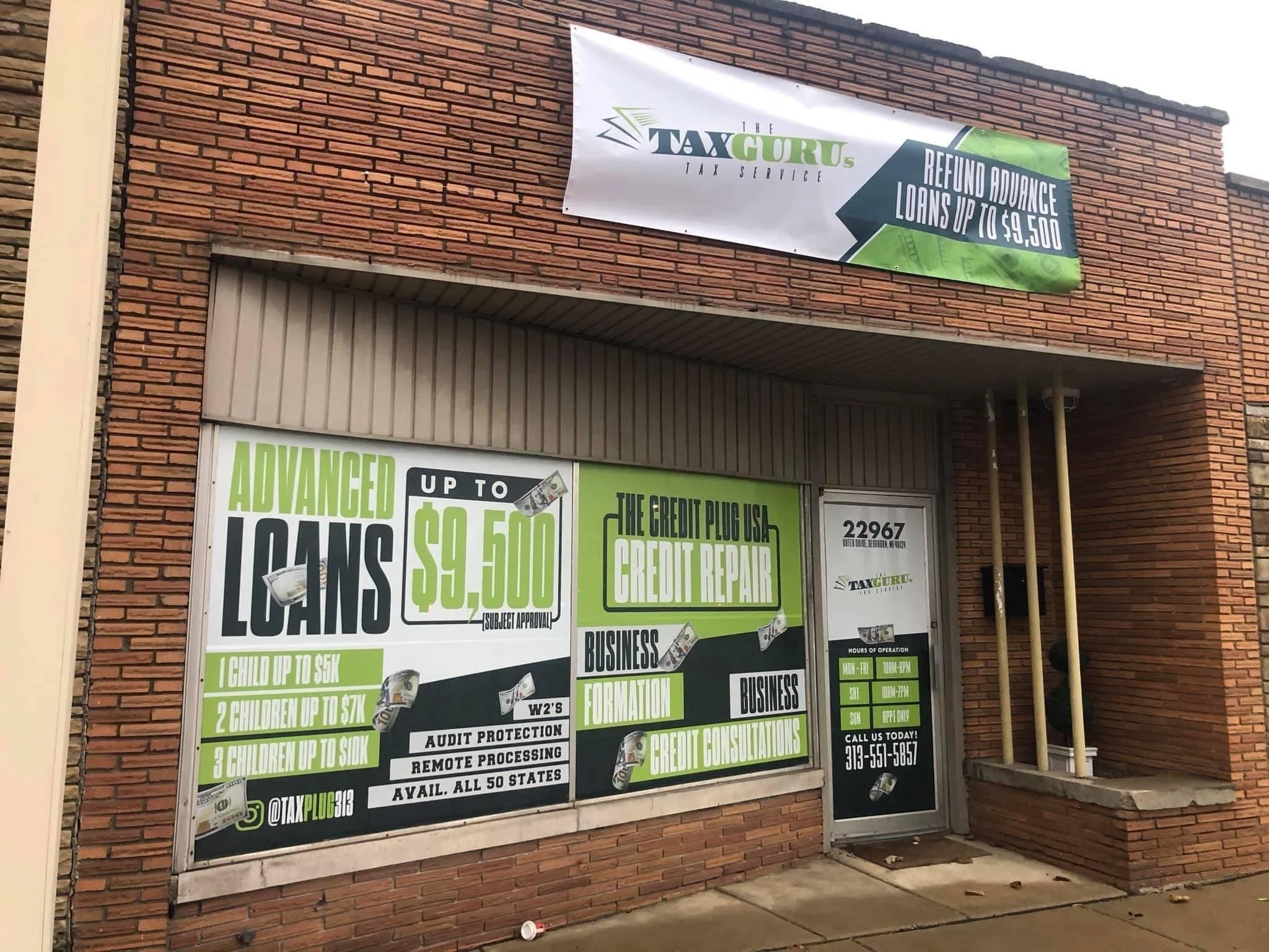 Brick building storefront advertising tax services with signs for advanced loans up to $9,500 and credit repair, displaying the company's contact information and hours of operation.