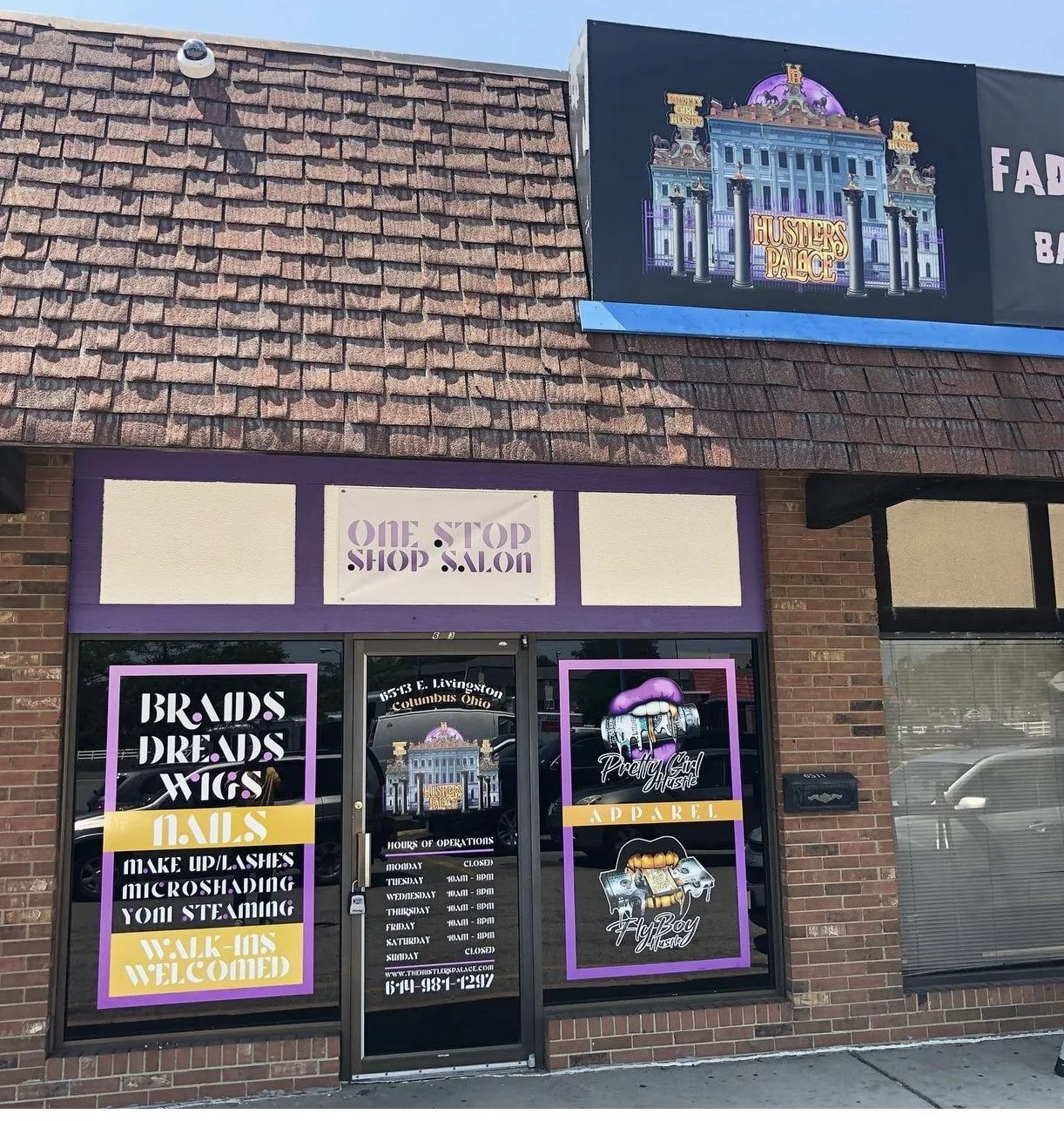 Exterior view of a retail store called "One Stop Shop & Salon" with purple signage and decorated windows indicating it offers brand and trend wigs, makeup, lashes, microshading, and steaming. The store is located at 153 E. Livingston, Columbus, Ohio,