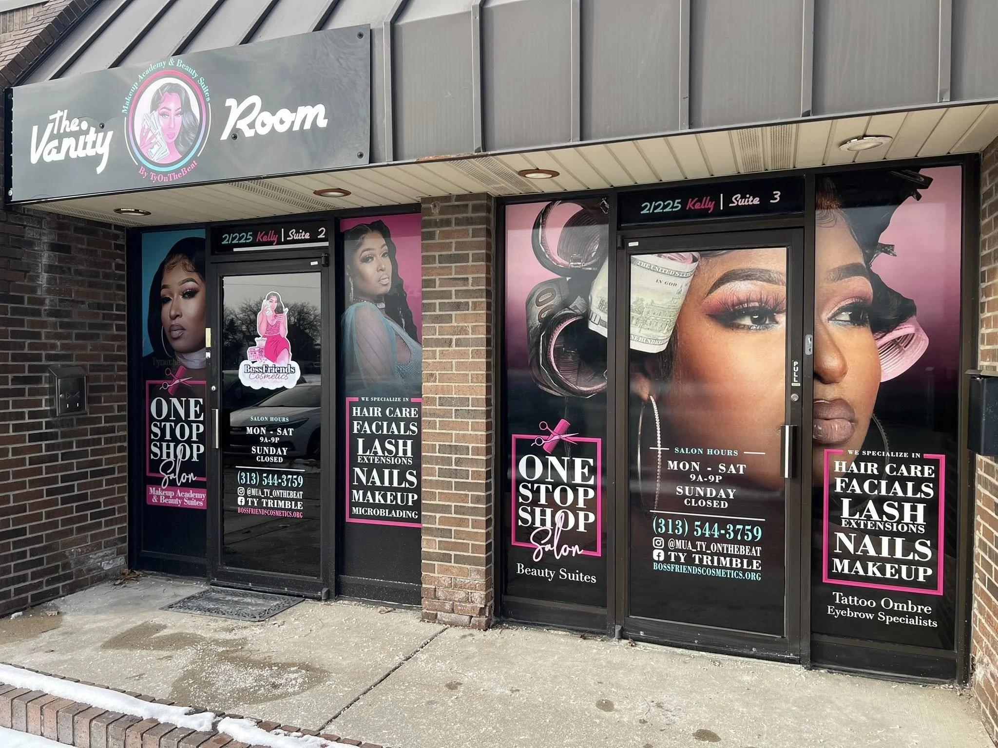 Front window and door signage for The Vanity Room, a beauty salon, displaying images of women with makeup, hair, and nails, and text listing services like hair care, facials, lash extensions, nails, makeup, and microblading. The salon’s hours and con