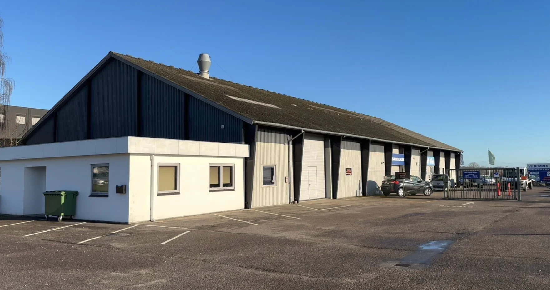 Et parkeringsområde foran en industriel bygning på Bygmstervej 21 i Ringe.