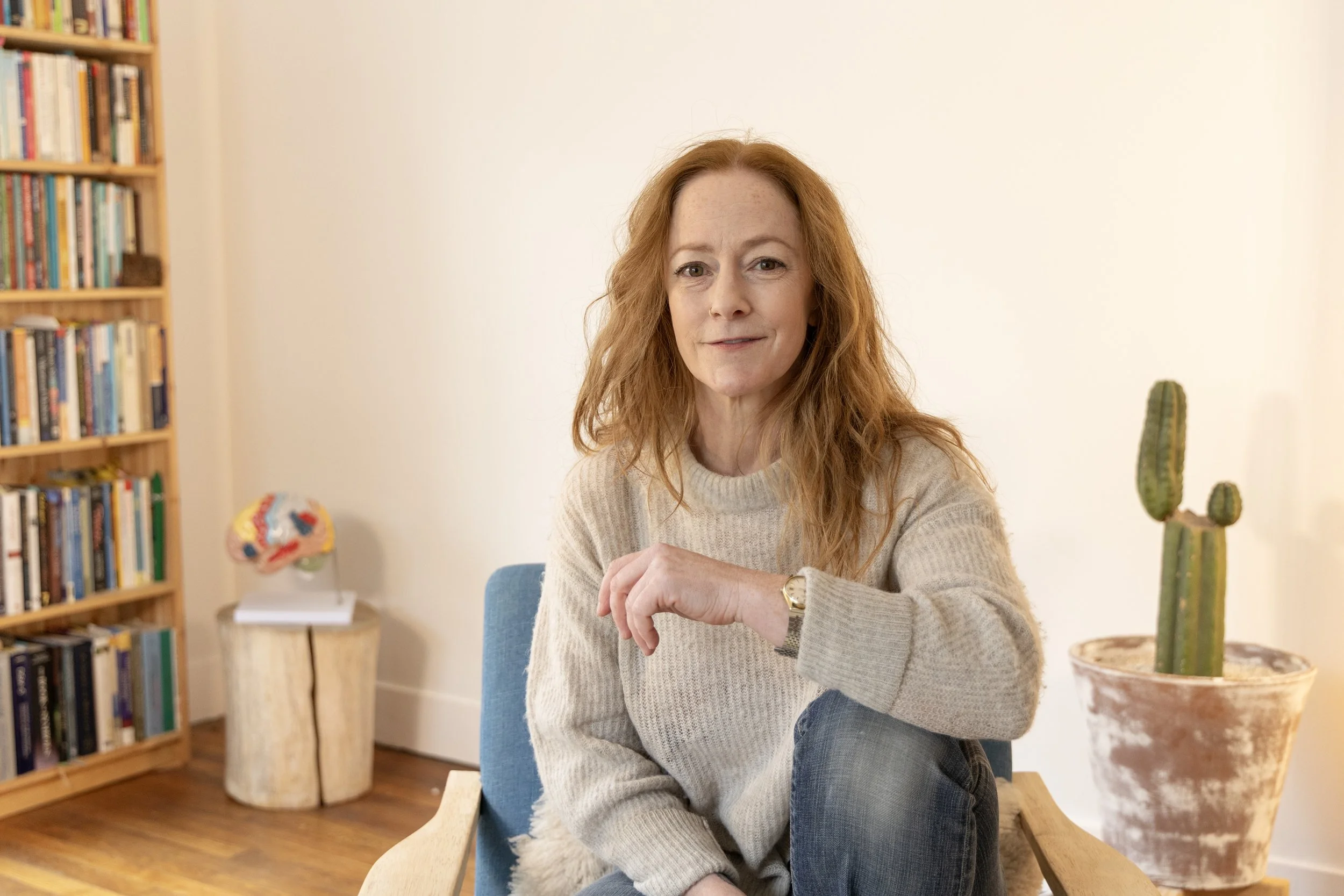 Woman therapist sitting in chair in home office with neutral colors