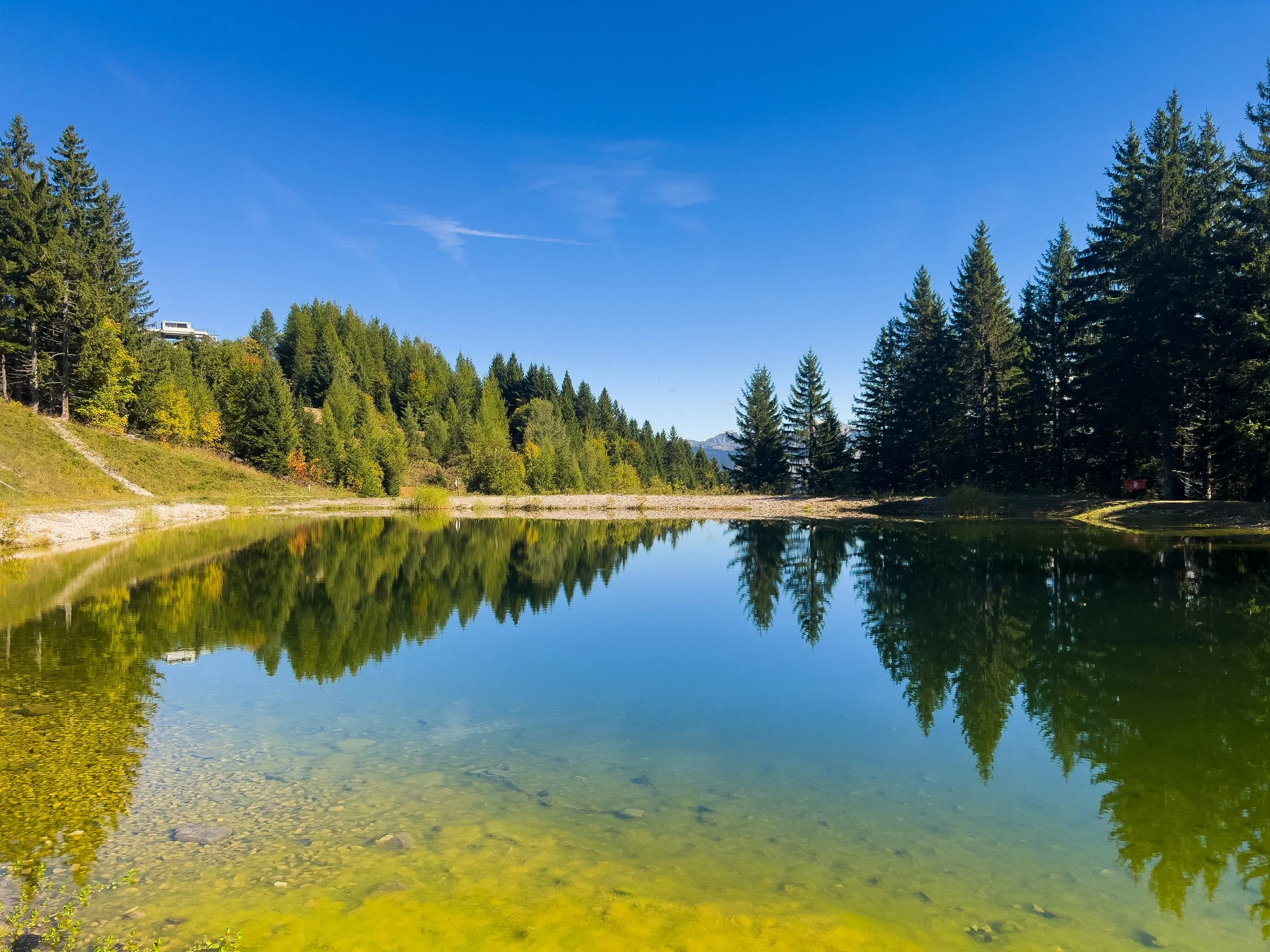 Scenic Alpine lake near Les Gets in the French Alps for summer activities and relaxation.