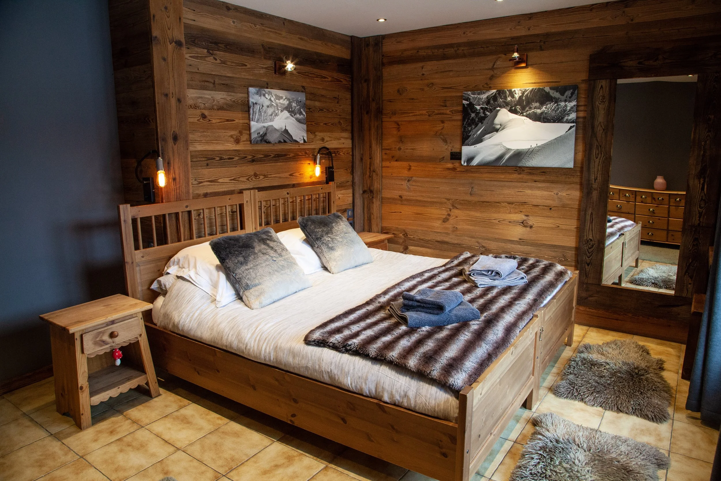 Comfortable double bedroom in luxury Les Gets chalet with wooden Alpine design.